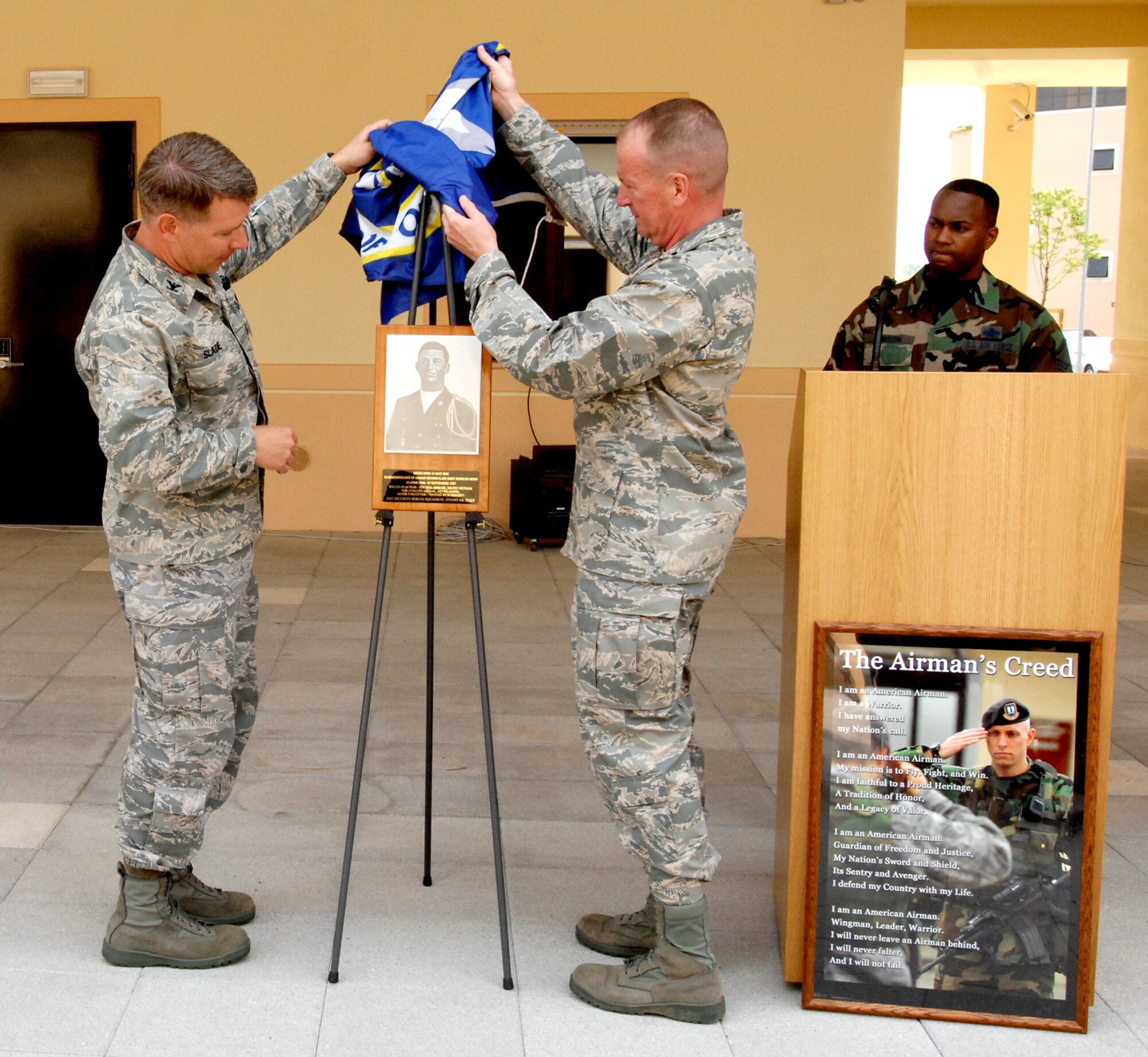 AVIANO AIR BASE, Italy - Colonel David Slade, 31st Mission Support Group commander, and Lt. Col. David Lynch, 31st Security Forces Squadron commander, uncover the dedication plaque at the new security forces squadron building dedication May 15.  The new SFS building is dedicated to Airman Second Class Jerry Moon, an Airman that gave the ultimate sacrifice in defense of the forces. (U.S. Air Force photo/Airman 1st Class Tabitha M. Mans)  