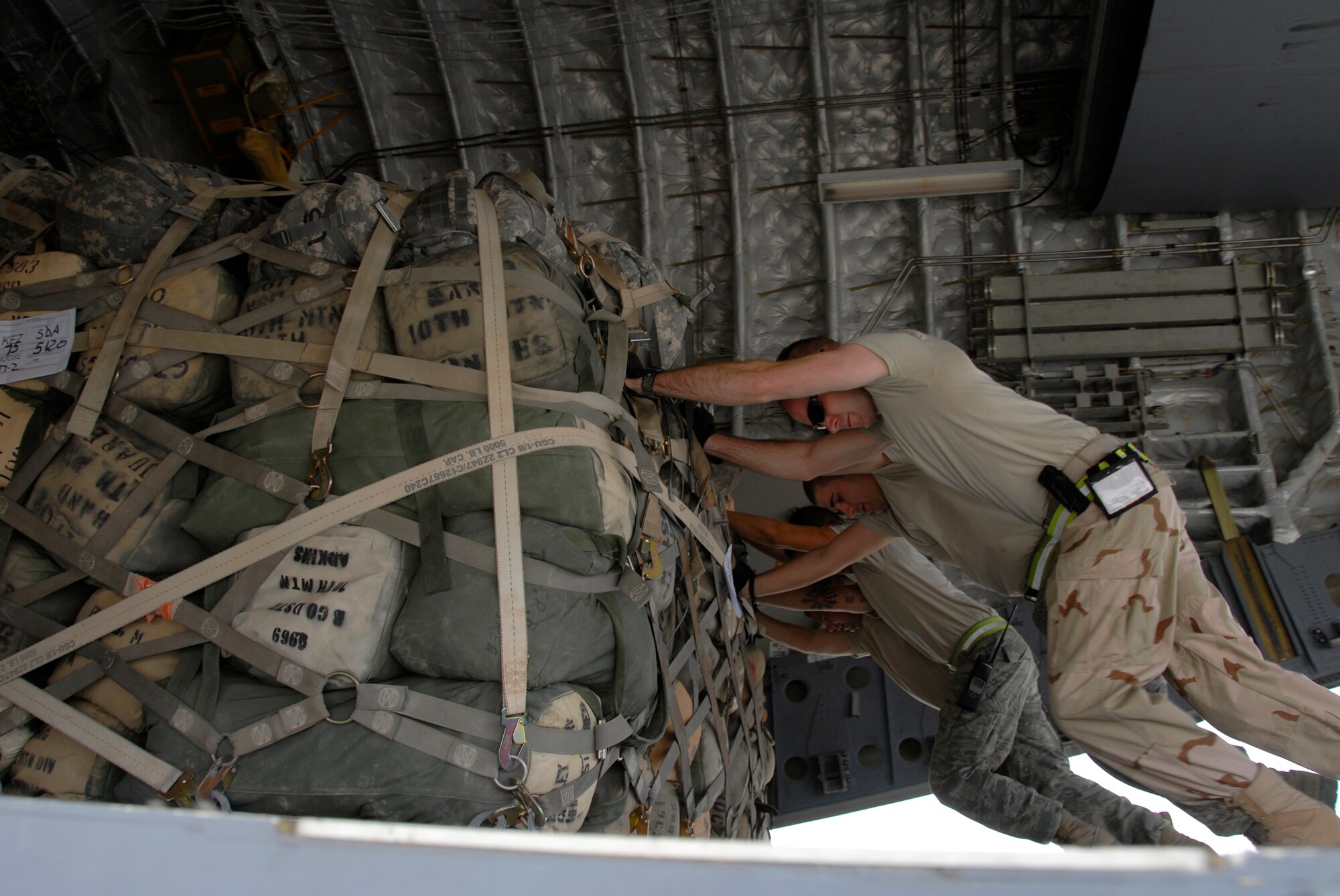 SOUTHWEST ASIA -- Airmen from the 386th Expeditionary Logistics Readiness Squadron's aerial port flight push a pallet onto a U.S. Air Force C-17 Globemaster III May 15, 2008, at an air base in the Persian Gulf Region. The aerial port flight handles all loading and unloading of military and coalition partners' aircraft departing and arriving the base and is responsible for processing all originating, through load, and terminating cargo. This flight is U.S. Central Command's largest passenger operation, handling more than 65,000 passengers a month in support of Operations Enduring and Iraqi Freedom. (U.S. Air Force photo/ Staff Sgt. Patrick Dixon)