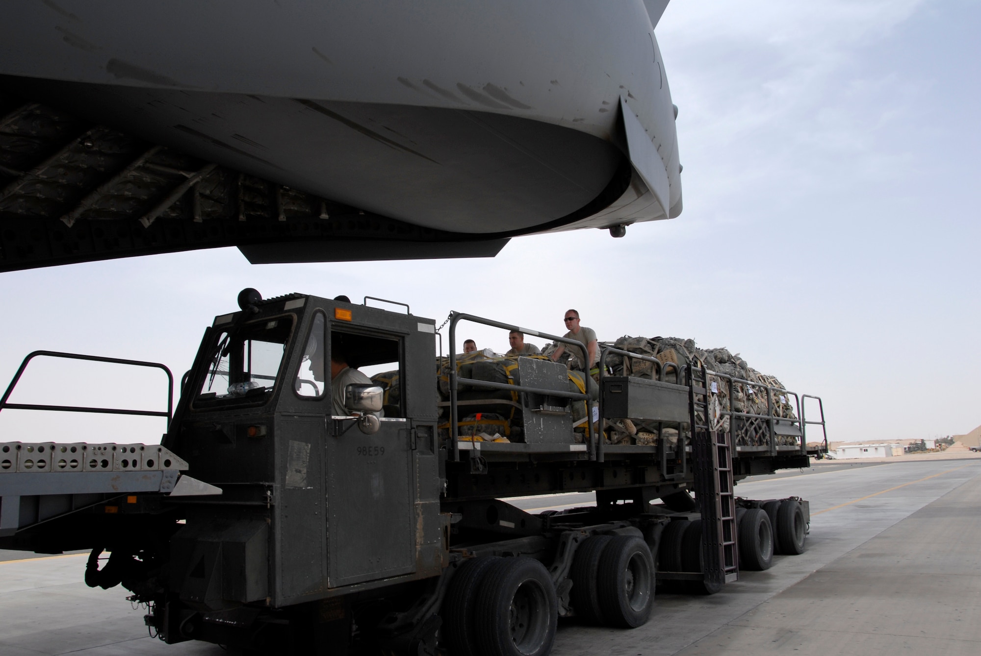 SOUTHWEST ASIA -- Airmen from the 386th Expeditionary Logistics Readiness Squadron's aerial port flight help push a pallet off of a 60K aircraft cargo loader and onto a U.S. Air Force C-17 Globemaster III May 15, 2008, at an air base in the Persian Gulf Region. The aerial port flight handles all loading and unloading of military and coalition partners' aircraft departing and arriving the base and is responsible for processing all originating, through load, and terminating cargo. This flight is U.S. Central Command's largest passenger operation, handling more than 65,000 passengers a month in support of Operations Enduring and Iraqi Freedom. (U.S. Air Force photo/ Staff Sgt. Patrick Dixon)