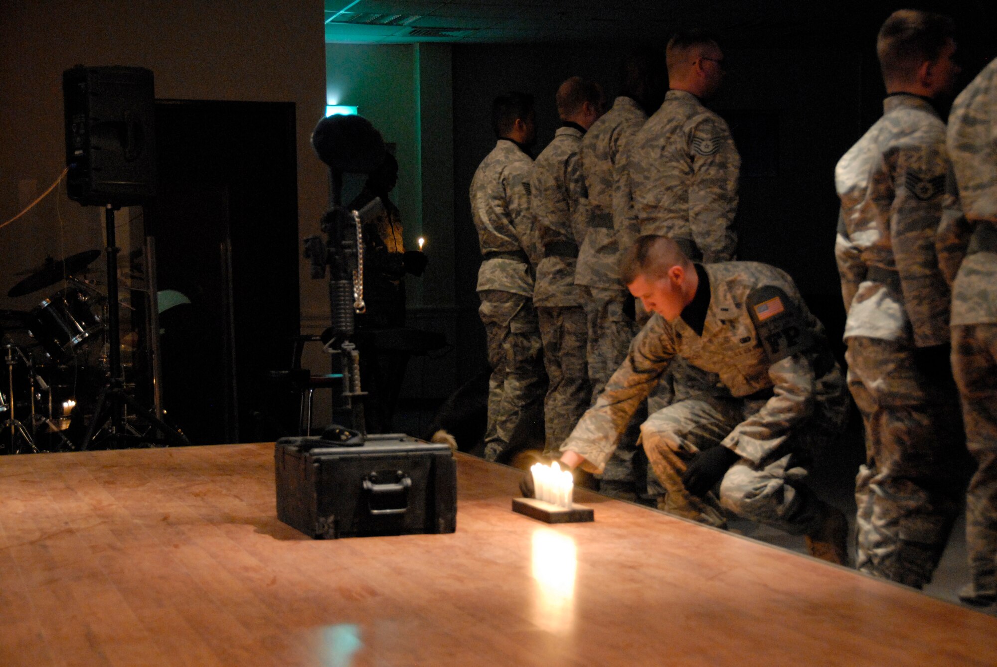 SOUTHWEST ASIA -- First Lt. Gregory DeGruchy, 386th Expeditionary Security Forces Squadron office in charge of force protection, places a candle in front of a memorial during a candle light vigil May 13, 2008, at an air base in the Persian Gulf Region. The candle light vigil is a memorial service that is designated to pay homage to law enforcement officers who selflessly gave their lives in the line of duty during the past year including Air Force Office of Special Investigation special agents, security forces 'Defenders' and military working dogs. Airmen 'Defenders' from the 386th ESFS commemorated National Police Week, May 11-17, hosting a series of events to celebrate the memory of their fallen comrades. (U.S. Air Force photo/ Capt. Jason McCree)