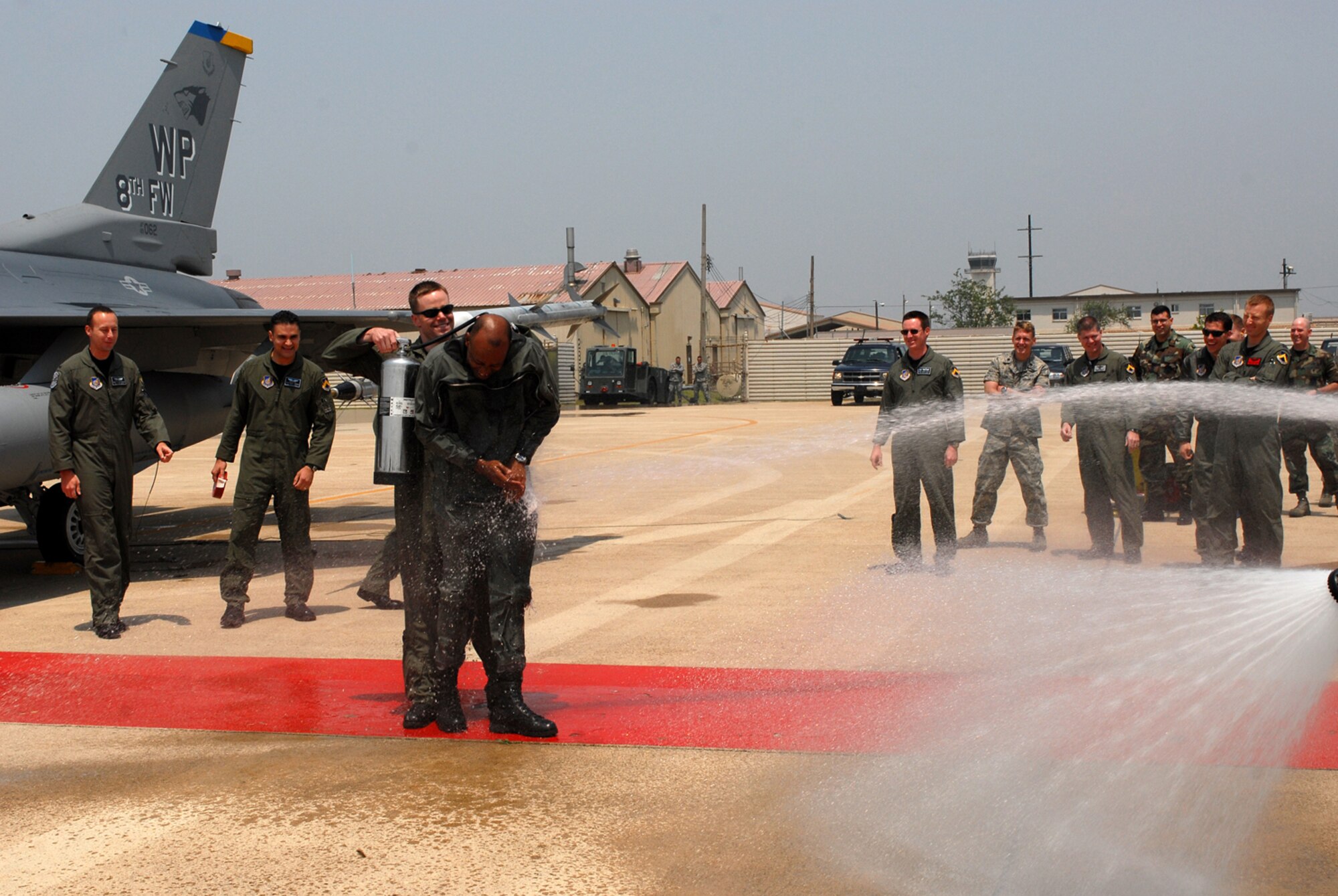 KUNSAN AIR BASE, Republic of Korea -- Captain Jayson Rickard, 35th Fighter Squadron weapons officer, participates in a hose down of Colonel CQ "Wolf" Brown, 8th Fighter Wing commander, during his return from his fini-flight May 19 here.  The fini-flight is a time-honored military aviation tradition marking the end of a pilot's or commander's time upon completion of their final flight.  (U.S. Air Force photo/Senior Airman Giang Nguyen)