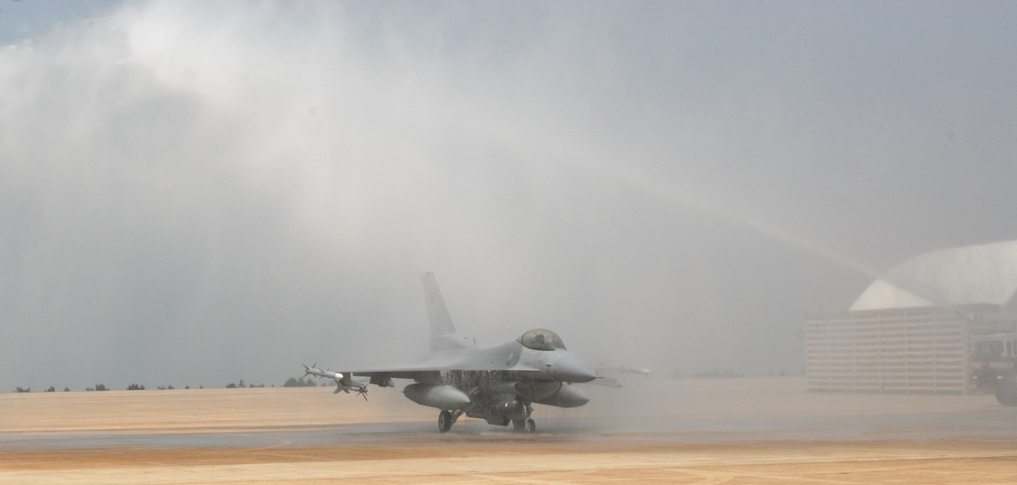 KUNSAN AIR BASE, Republic of Korea -- Fire trucks spray water over an F-16, during Colonel CQ "Wolf" Brown, 8th Fighter Wing commander's, fini-flight May 19 here.  The fini-flight is a time-honored military aviation tradition marking the end of a pilot's or commander's time upon completion of their final flight. (U.S. Air Force photo/Senior Airman Giang Nguyen)
