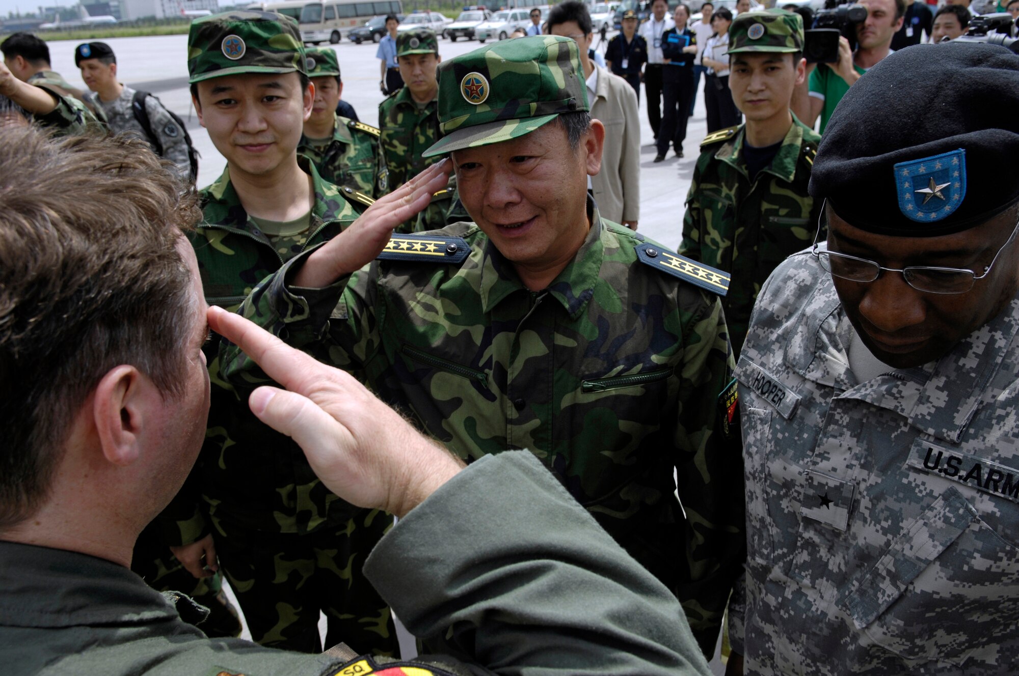 CHENGDU SHUANGLIU INTERNATIONAL AIRPORT, People’s Republic of China (May 18, 2008) – Major Anthony Davis, a C-17 pilot with the Hawaii Air National Guard's 204th Airlift Squadron at Hickam Air Force Base, Hawaii, exchanges salutes with Senior Captain GUAN Youfei, Deputy Director of the Chinese Ministry of Defense's Foreign Affairs Office, at Chengdu Shuangliu International Airport. Also pictured are Major WU Qian, Staff Officer at the Chinese Ministry of Defense's American and Oceanic Affairs Bureau, and U.S. Army Brigadier General Charles W. Hooper, U.S. Defense Attache. The United States Pacific Command support of earthquake relief efforts was authorized by Secretary of Defense Robert Gates, in support of the U.S. Department of State. (US Air Force photo / Tech. Sgt. Chris Vadnais)