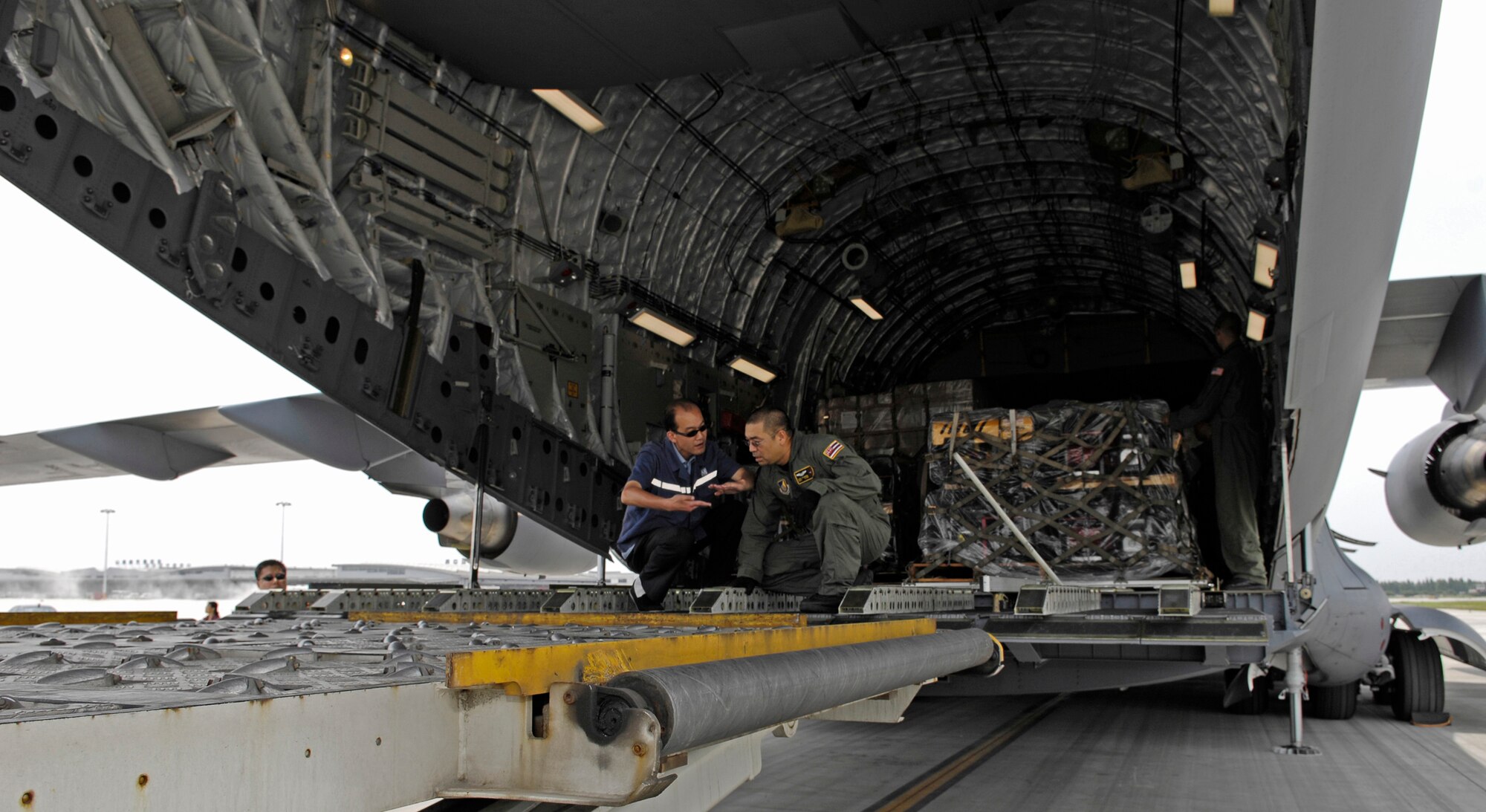 CHENGDU SHUANGLIU INTERNATIONAL AIRPORT, People’s Republic of China (May 18, 2008) – Master Sgt. Kurt Uchimura, a C-17 loadmaster assigned to the Hawaii Air National Guard's 204th Airlift Squadron, discusses the offload plan with an airport official at Chengdu Shuangliu International Airport on May 17, 2008. The C-17 is carrying nearly 100,000 pounds of food, blankets, tools, and shelter materials. The United States Pacific Command support of earthquake relief efforts was authorized by Secretary of Defense Robert Gates, in support of the U.S. Department of State. (US Air Force photo / Tech. Sgt. Chris Vadnais)