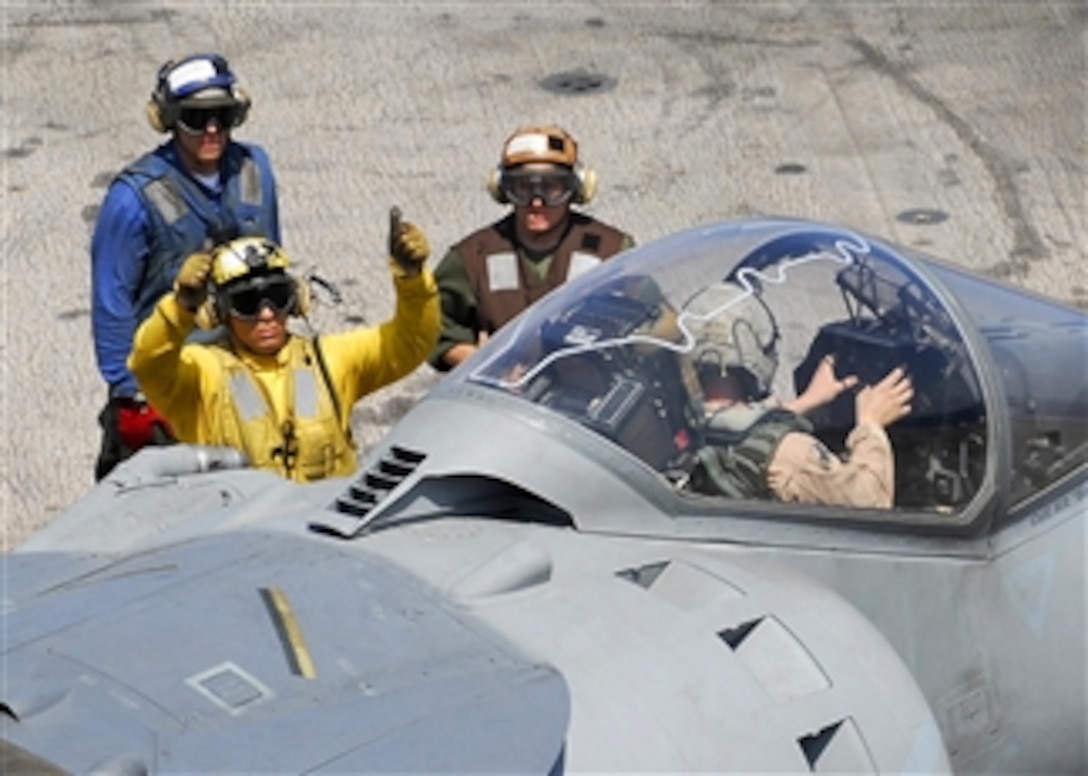 U.S. Navy flight deck crewmen use hand signals to communicate with the pilot of an AV-8B Harrier aircraft during flight operations aboard the amphibious assault ship USS Peleliu (LHA 5) while underway in the Pacific Ocean on May 15, 2008.  