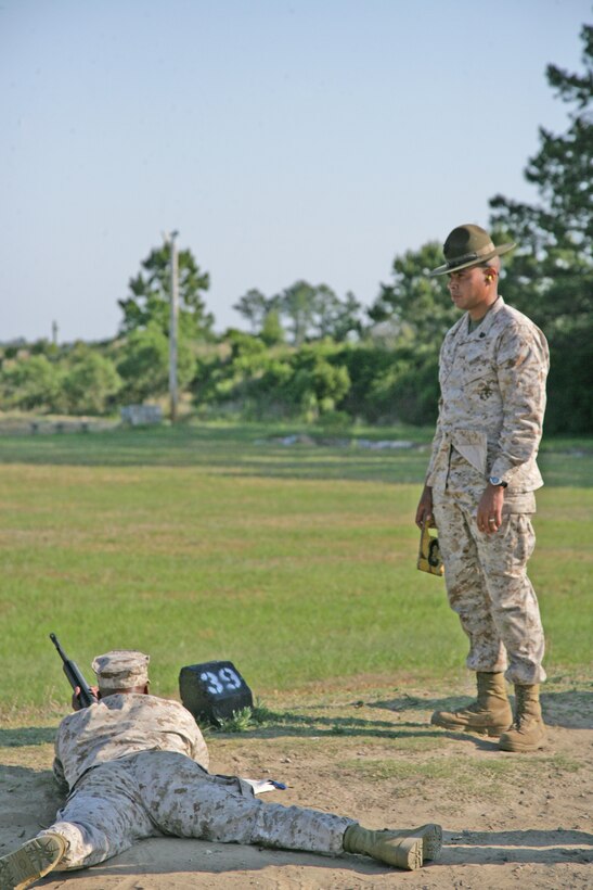 Sgt. Alfonzo Mayora, a Chosin Range block noncommissioned officer, watches over recruits firing on his section of the range’s firing line.