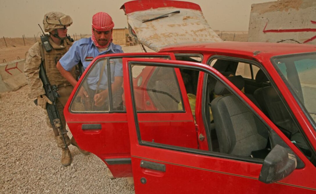 Lance Cpl. Adam J. Desso, a team leader with 1st Battalion, 9th Marine Regiment, supports and mentors an Iraqi Policeman during a routine vehicle search at an Enemy Control Point. While, the battalion’s leaders have stressed the importance of creating a great relationship with the policemen, they also put emphasis on monitoring the Iraqi police as they grow to a high-level that can eventually become an independent force, a feat several stations have already accomplished.