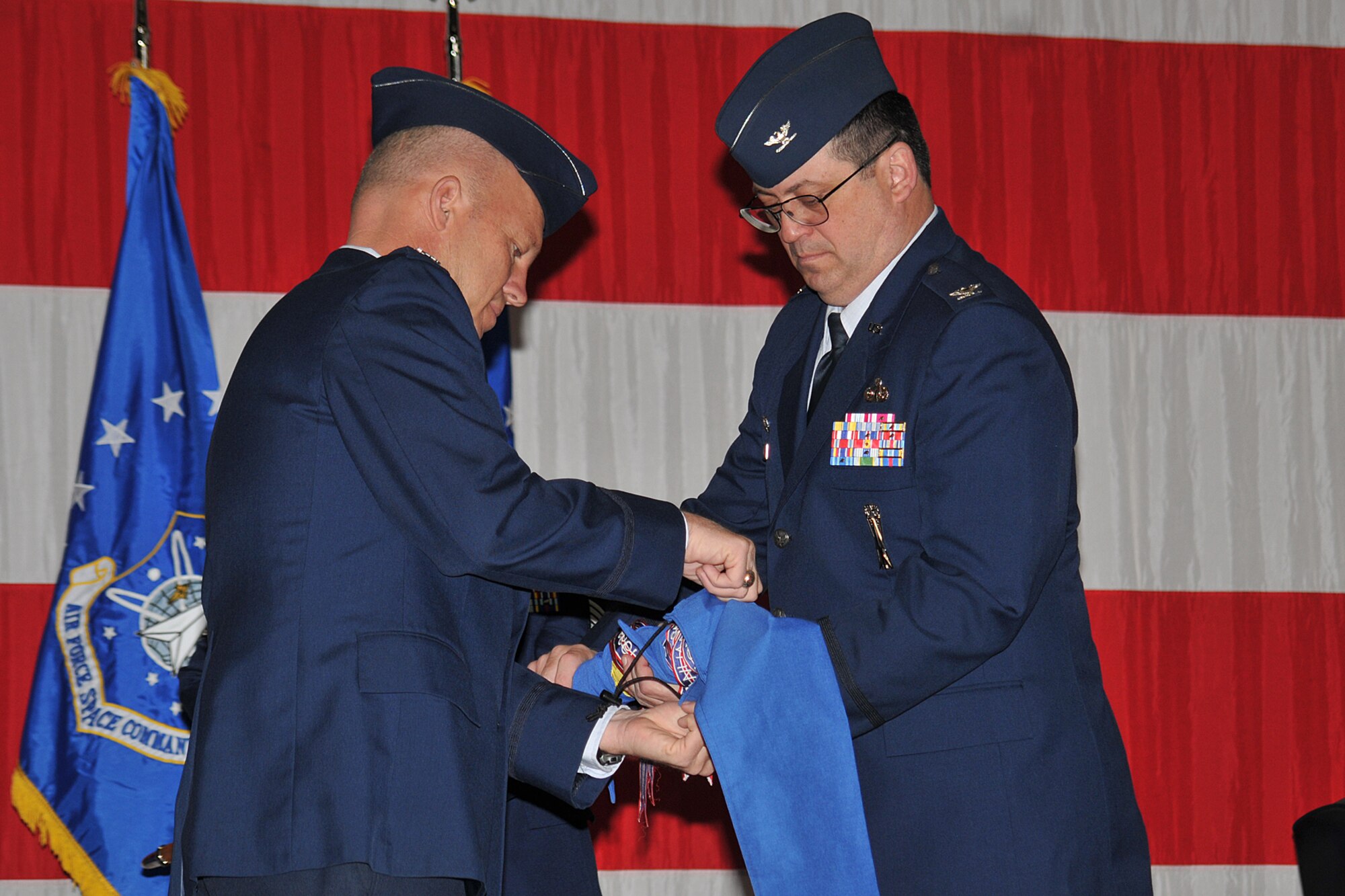 Col. Jay Raymond, 21st Space Wing commander (left), and Col. Lyman Faith case the 21st Maintenance Group’s guideon during the unit’s deactivation ceremony May 15 at Peterson Air Force Base, Colo. The 21st MXG officially deactivated as part of an effort to better organize the 21st SW’s units. Casing a unit’s guideon is a rich part of a unit’s history, from activation to deactivation. Colonel Faith is the 21st MXG’s last commander. (U.S. Air Force photo/Larry Hulst)