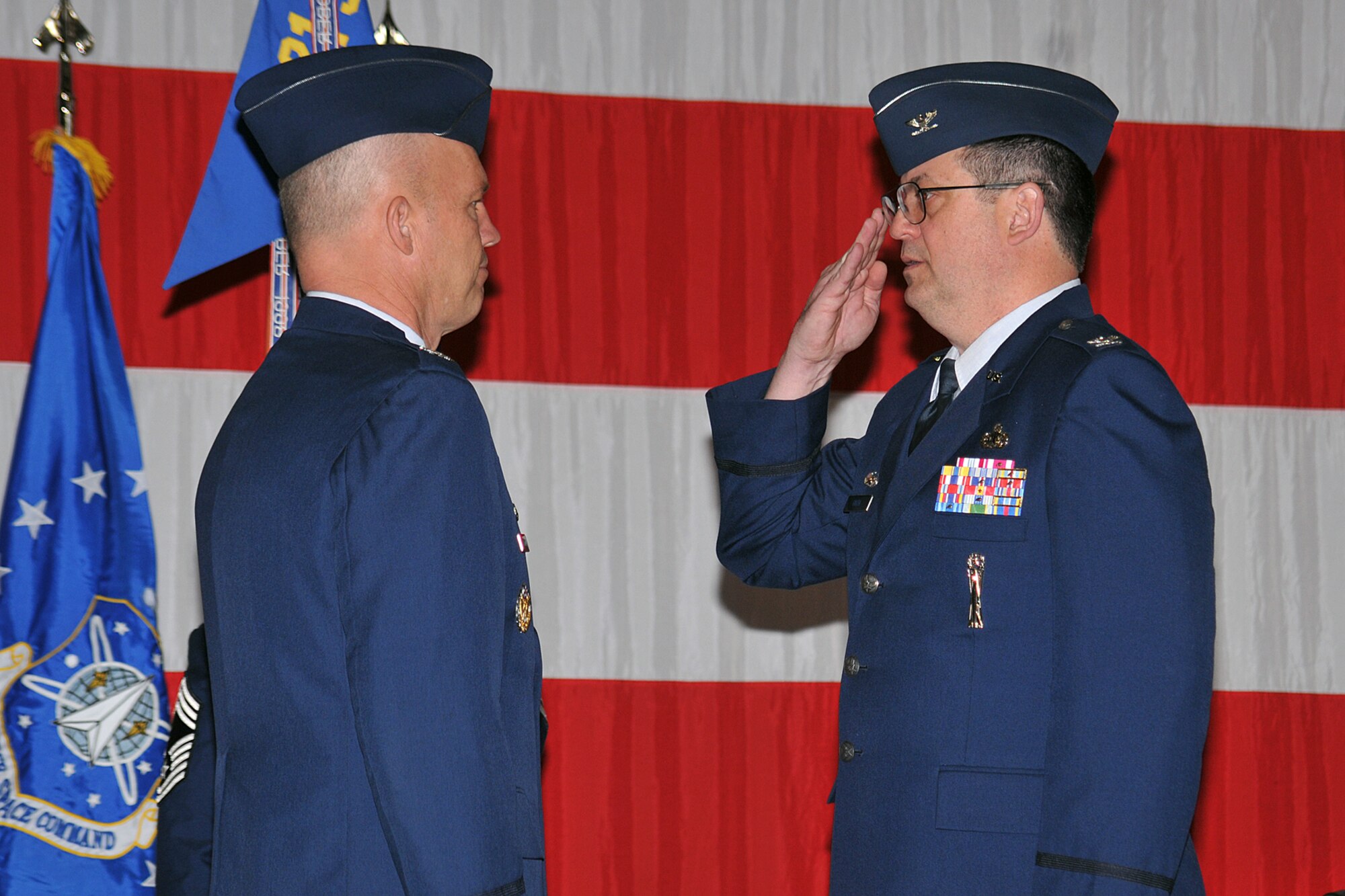 Col. Lyman Faith, outgoing 21st Maintenance Group commander (right), salutes Col. Jay Raymond during the 21st Maintenance Group deactivation ceremony May 15 at Peterson Air Force Base, Colo. The 21st MXG officially deactivated as part of an effort to better organize the 21st Space Wing’s units. Colonel Raymond is the 21st SW commander. (U.S. Air Force photo/Larry Hulst)