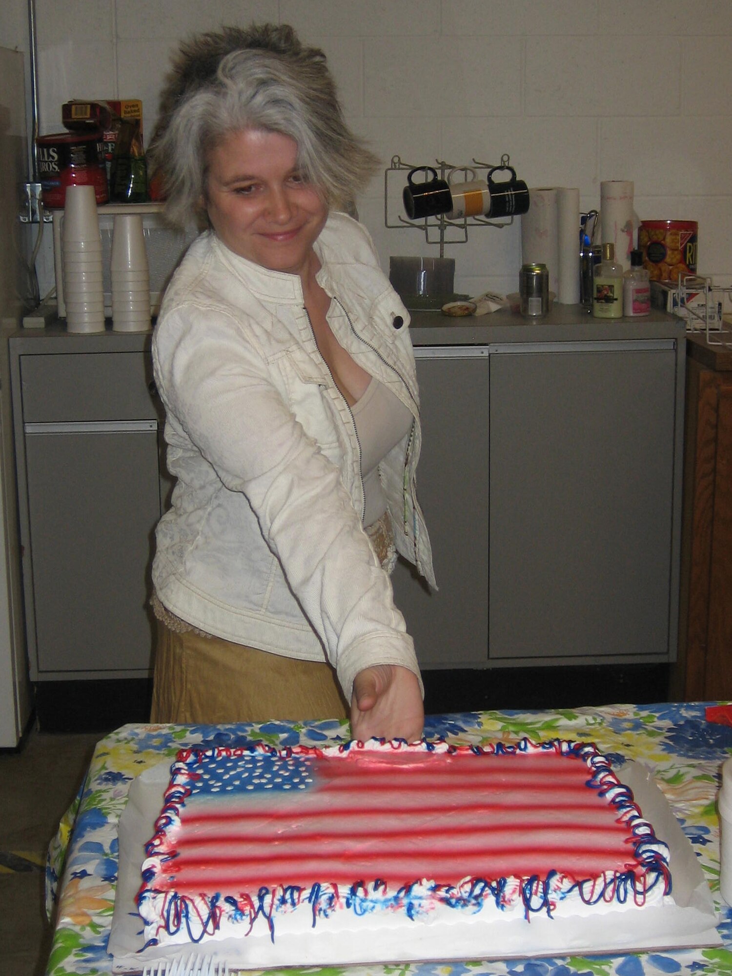 Heidi Whelan, former Ellsworth Thrift Shop manager, offers cake to attendees of the ribbon-cutting ceremony of the "B-one Yard." The "B-one Yard" combines the Base Thrift Shop and Airman's Attic, whose primary missions are to lend a helping hand to junior enlisted personnel; this ceremony marked the colocation of the two services. (Courtesy photo/Kristi Hullings)