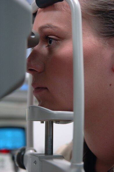Staff Sgt. Crystal Jacquot, 28th Bomb Wing NCO in charge of wing information management, experiences a puff of air from a non-contact tonometer used to determine her eyes' intraocular pressure here, May 20. Intraocular pressure is a measurement of the fluid pressure inside the eye that helps the eye maintain its globular shape. (U.S. Air Force photo/Airman Corey Hook)
