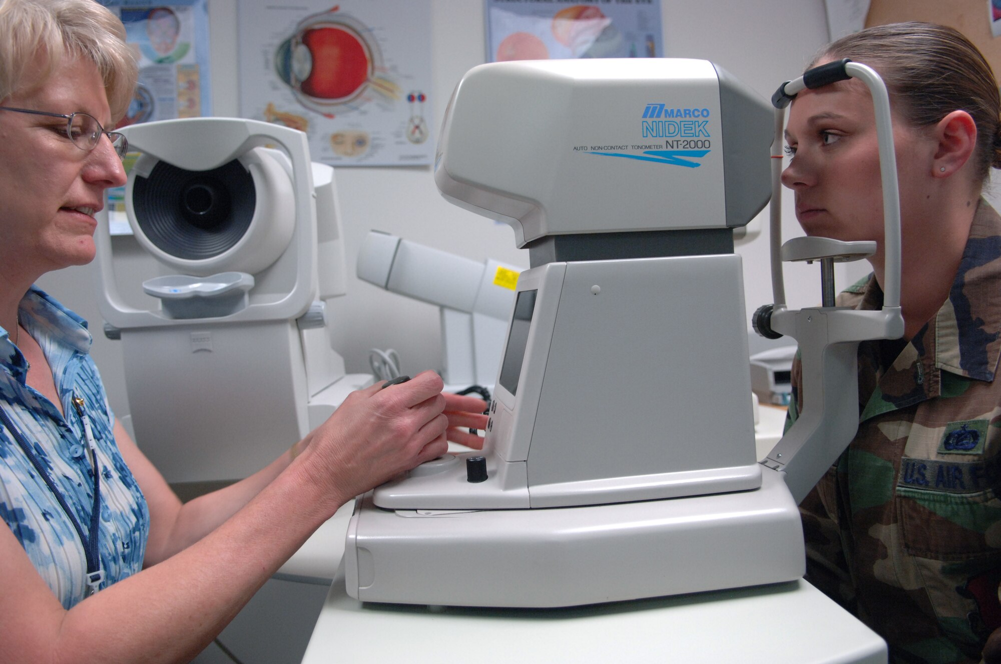 Carol McNulty, 28th Medical Group optometry technician, examines Staff Sgt. Crystal Jacquot, 28th Bomb Wing non-commissioned officer in charge wing information management, eyes by checking her intraocular pressure with a non-contact tonometer, May 20.  The non-contact tonometer determines the intracular pressure by applying a burst of air into each eye.  (U.S. Air Force photo/ Airman Corey Hook)