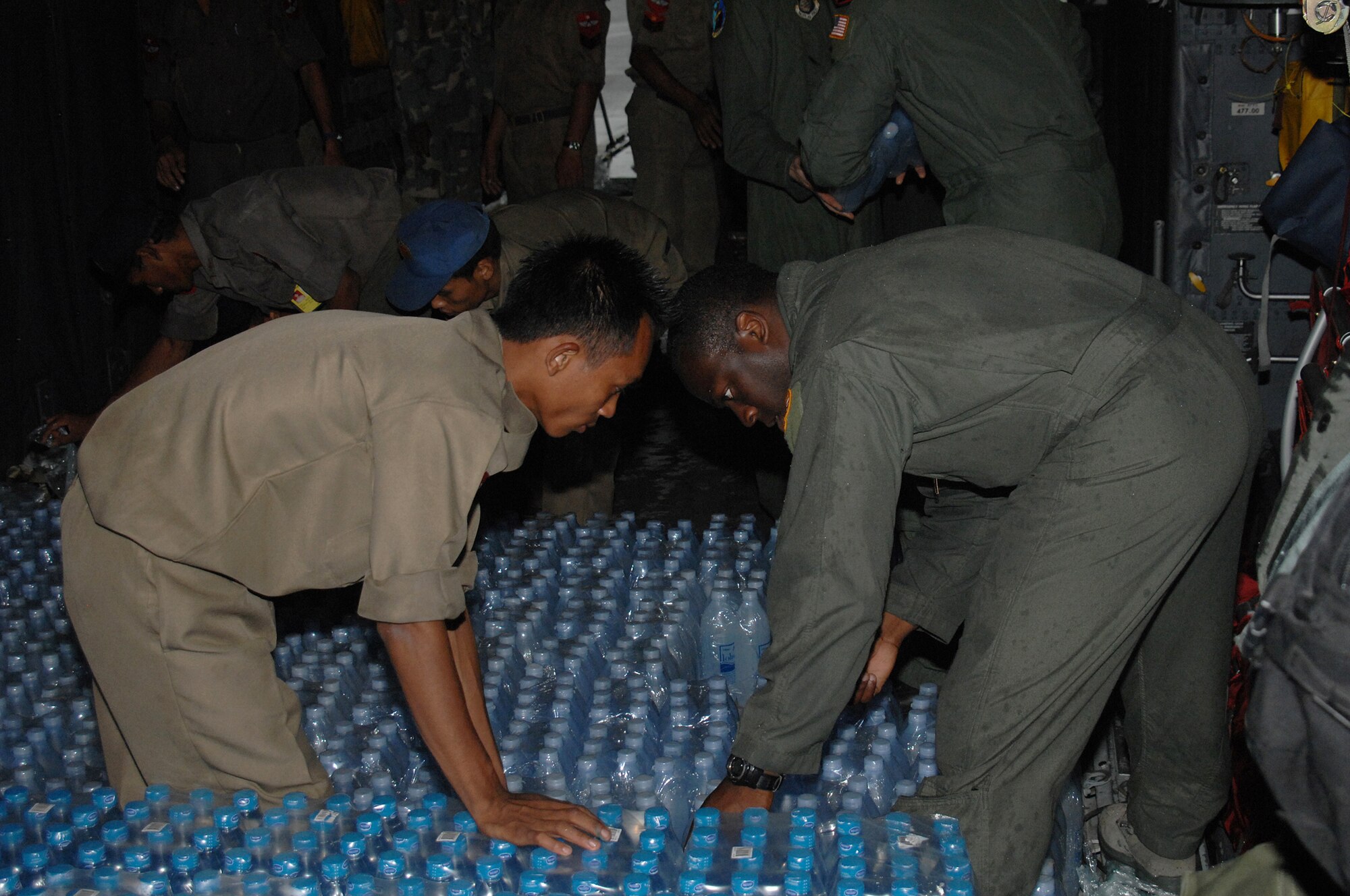YANGON, Burma--  Captain Kristopher Duckett, a C-130 Hercules pilot, assists with the delivery of humanitarain relief supplies delivered to Burma May 19. Capt. Duckett is assigned to the 374th Airlift Wing from Yokota Air Base, Japan. Approximately 15,000 lbs of water, water containers and mosquito netting were unloaded at Yangon International Airport. The Airmen are deployed in support of Operation Caring Response. (U.S. Air Force photo by Senior Airman Sonya Croston)