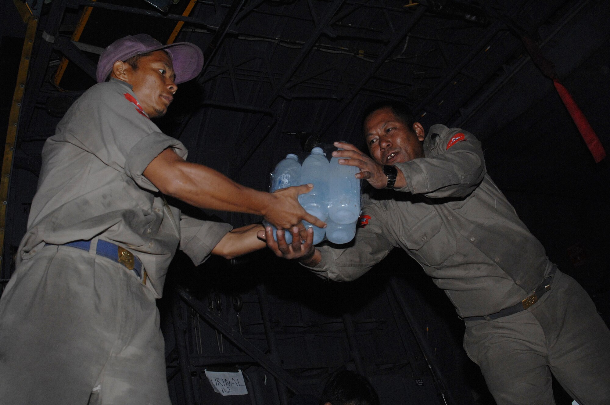 YANGON, Burma--  Burmese military members load a truck with bottles of water from a U.S. Air Force C-130 Hercules May 19. Approximately 15,000 lbs of water, water containers and mosquito netting were unloaded at Yangon International Airport. The Airmen are deployed in support of Operation Caring Response. (U.S. Air Force photo by Senior Airman Sonya Croston)