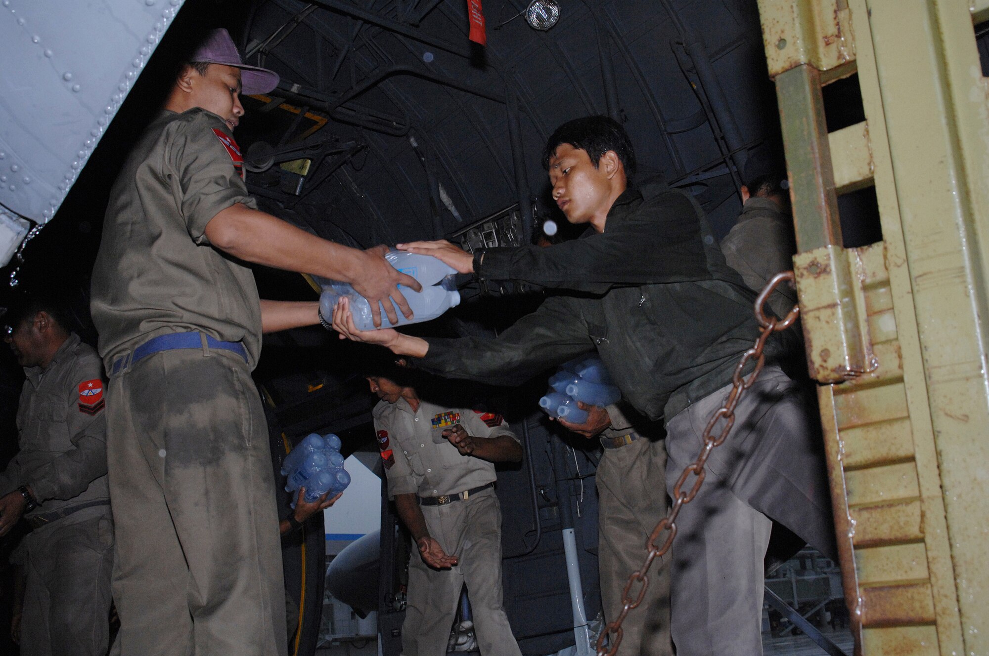 YANGON, Burma--  Burmese military members load a truck with bottles of water from a U.S. Air Force C-130 Hercules May 19. Approximately 15,000 lbs of water, water containers and mosquito netting were unloaded at Yangon International Airport. The Airmen are deployed in support of Operation Caring Response. (U.S. Air Force photo by Senior Airman Sonya Croston)