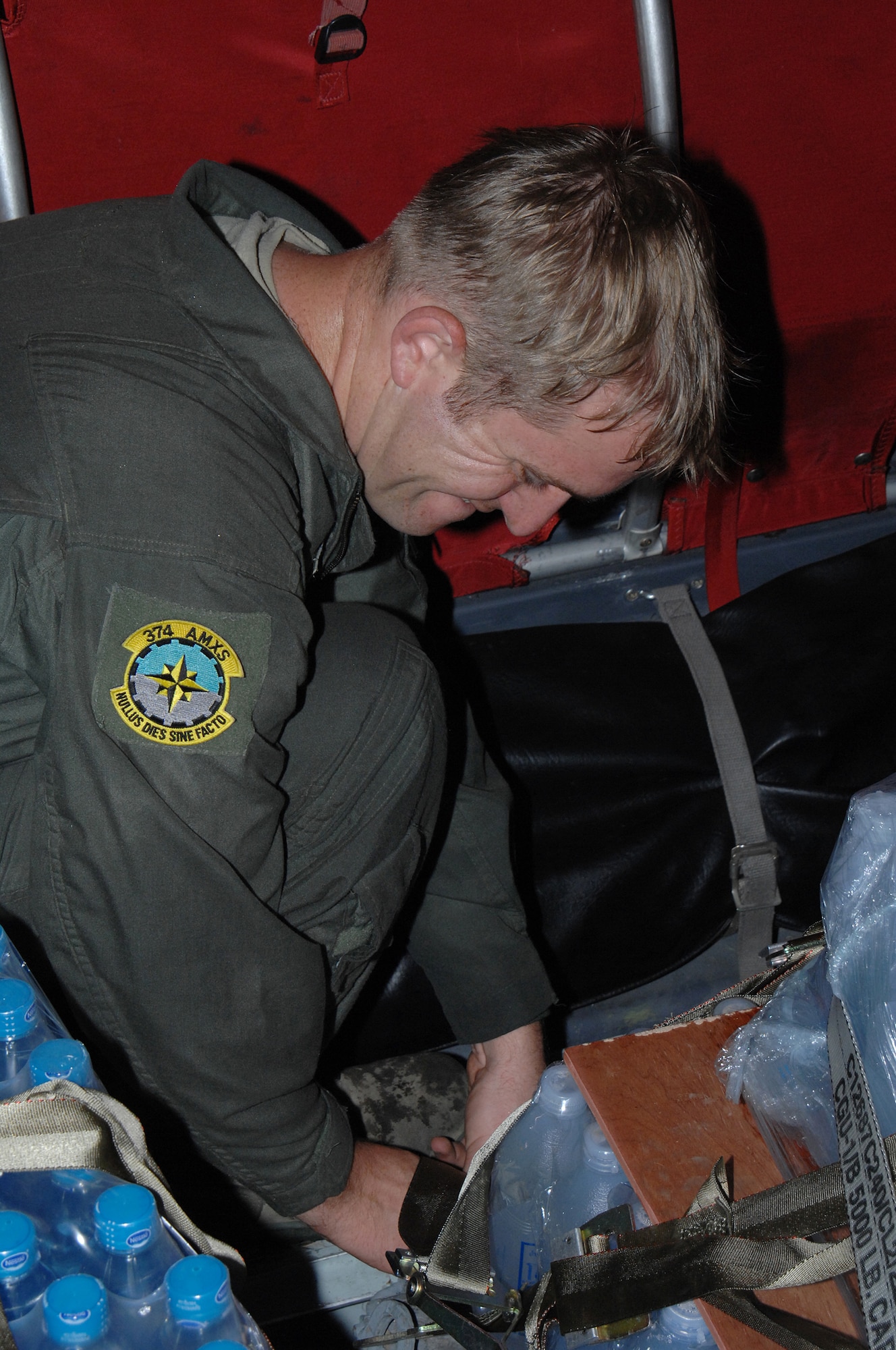 Yangon, Burma - Staff Sgt. Joseph Strutton, unstraps cargo netting from a pallet of water during the delivery into Burma May 19. Sergeant Strutton is assigned to the 374th Airlift Wing from Yokota Air Base, Japan. The Airmen are deployed in support of Operation Caring Response. (U.S. Air Force photo by Senior Airman Sonya Croston)