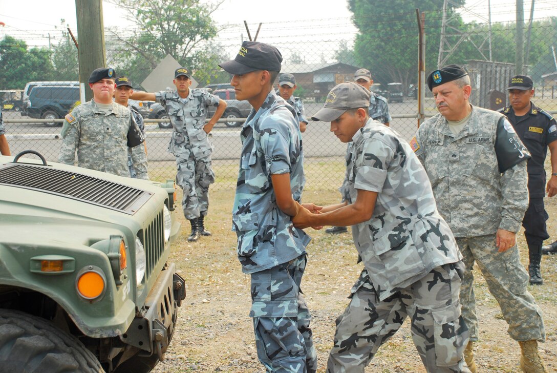 SOTO CANO AIR BASE, Honduras--Army Sgt. Manuel Perez-Hernandez observes a Honduran National Police Academy cadet?s apprehension efforts during a high-risk traffic stop exercise here May 16 as part of a subject matter exchange between Joint Task Force-Bravo?s Joint Security Forces personnel and more than two dozen cadets. Beside providing handcuffing and searching and high-risk traffic stop execution advice, JSF personnel also offered knowledge pertaining to other law enforcement procedures like vehicle and building searches, self aid and buddy care and field sobriety tests. (U.S. Air Force photo by Tech. Sgt. William Farrow)