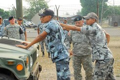 SOTO CANO AIR BASE, Honduras--Army Sgt. Manuel Perez-Hernandez guides a Honduran National Police Academy cadet through a high-risk traffic stop exercise here May 16 during a subject matter exchange between Joint Task Force-Bravo?s Joint Security Forces personnel and more than two dozen cadets. According to Honduran police academy officials, upon July?s graduation date the cadets will be paired with experienced police officers for on-the-job training, often on beats in some of the rougher neighborhoods in Honduras? large cities. (U.S. Air Force photo by Tech. Sgt. William Farrow)