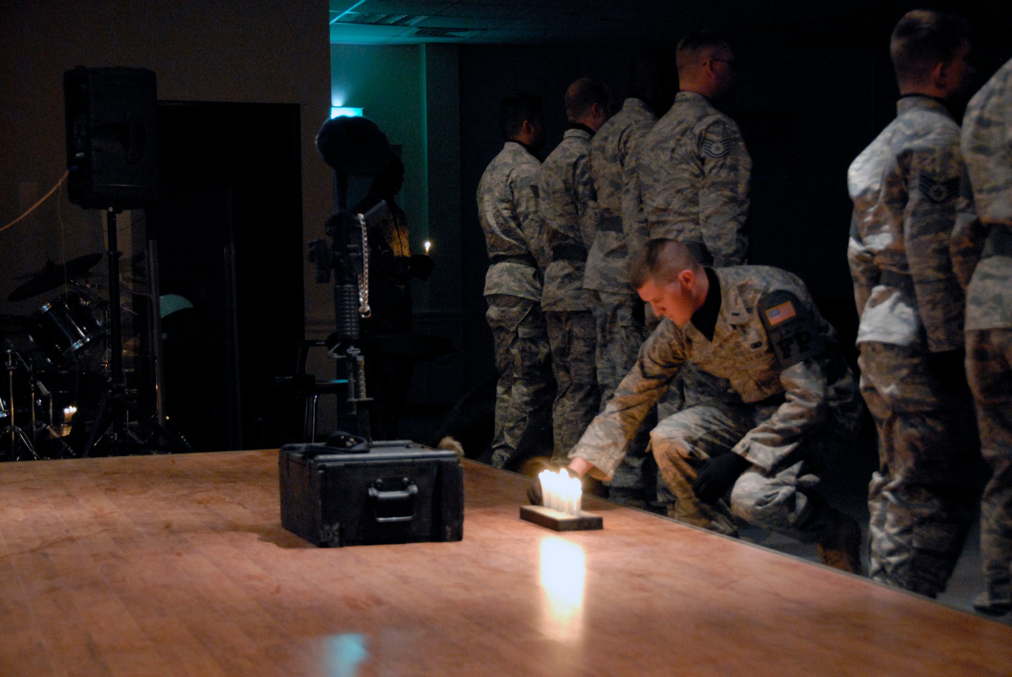 1st Lt. Gregory DeGruchy places a candle in front of a memorial during a candlelight vigil May 13 at an air base in Southwest Asia. The candlelight vigil was a memorial service designated to pay homage to law enforcement officers who selflessly gave their lives in the line of duty during the past year including Air Force Office of Special Investigation special agents, security forces members and military working dogs. Lieutenant DeGruchy is the 386th Expeditionary Security Forces Squadron officer in charge of force protection. (U.S. Air Force photo/Capt. Jason McCree) 
