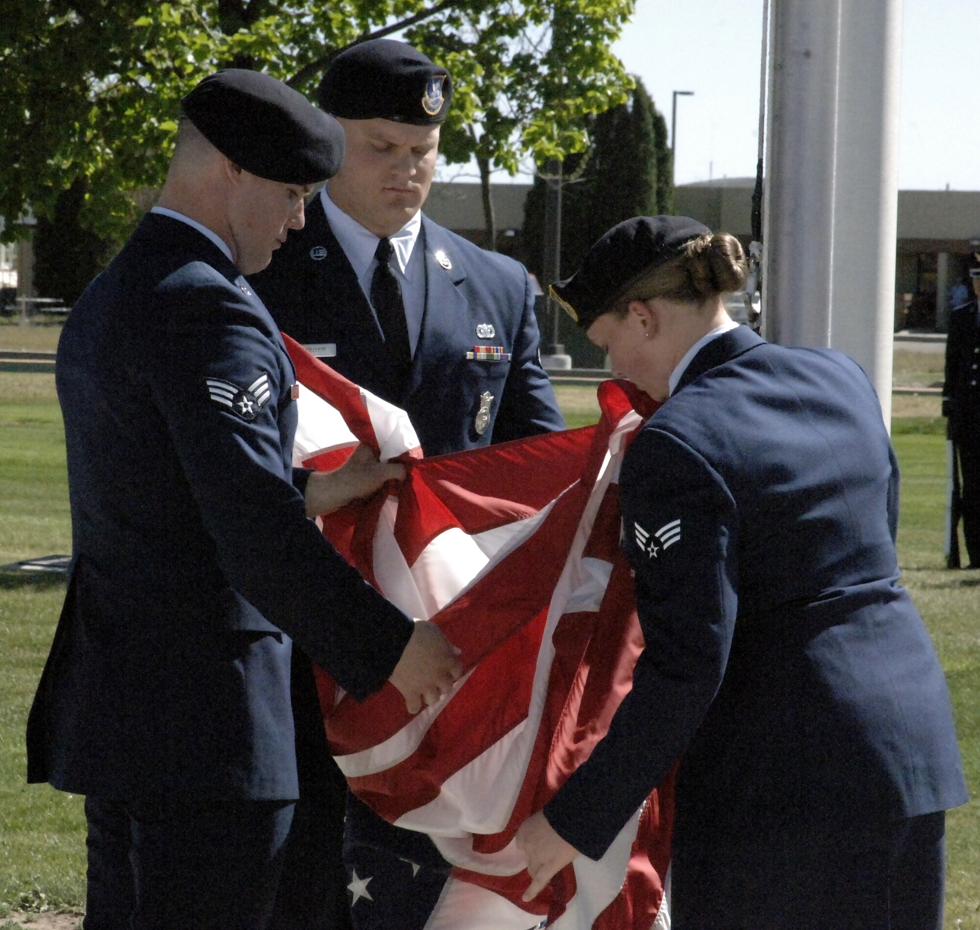 MOUNTAIN HOME AIR FORCE BASE, Idaho – (left to right) Senior Airman Keith Kozak, Airman 1st Class Cole Cournyer and Senior Airman Katrina Aide, 366th Security Forces Squadron, fold the colours during a retreat ceremony honoring fallen security forces members and law enforcement officials. National Police Week honors personnel in law enforcement and pay tribute to those who gave their lives while serving their community. (U.S. Air Force photo/ Staff Sgt. Brian Stives)