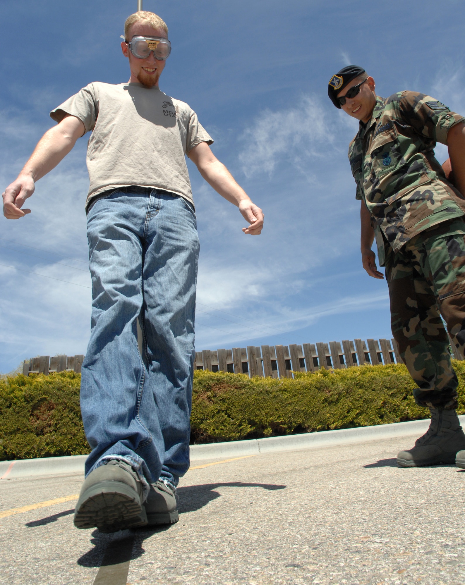MOUNTAIN HOME AIR FORCE BASE, Idaho - Staff Sgt. Jerry Tourtillott, 366th Security Forces Squadron patrolman, watches as Donald Miller III tries walking a line while wearing drunken vision glasses during National Police Week May 17. The week was to honor personnel in law enforcement and pay tribute to those who gave their lives while serving their community. (U.S. Air Force photo/ Airman 1st Class Stephany Miller)