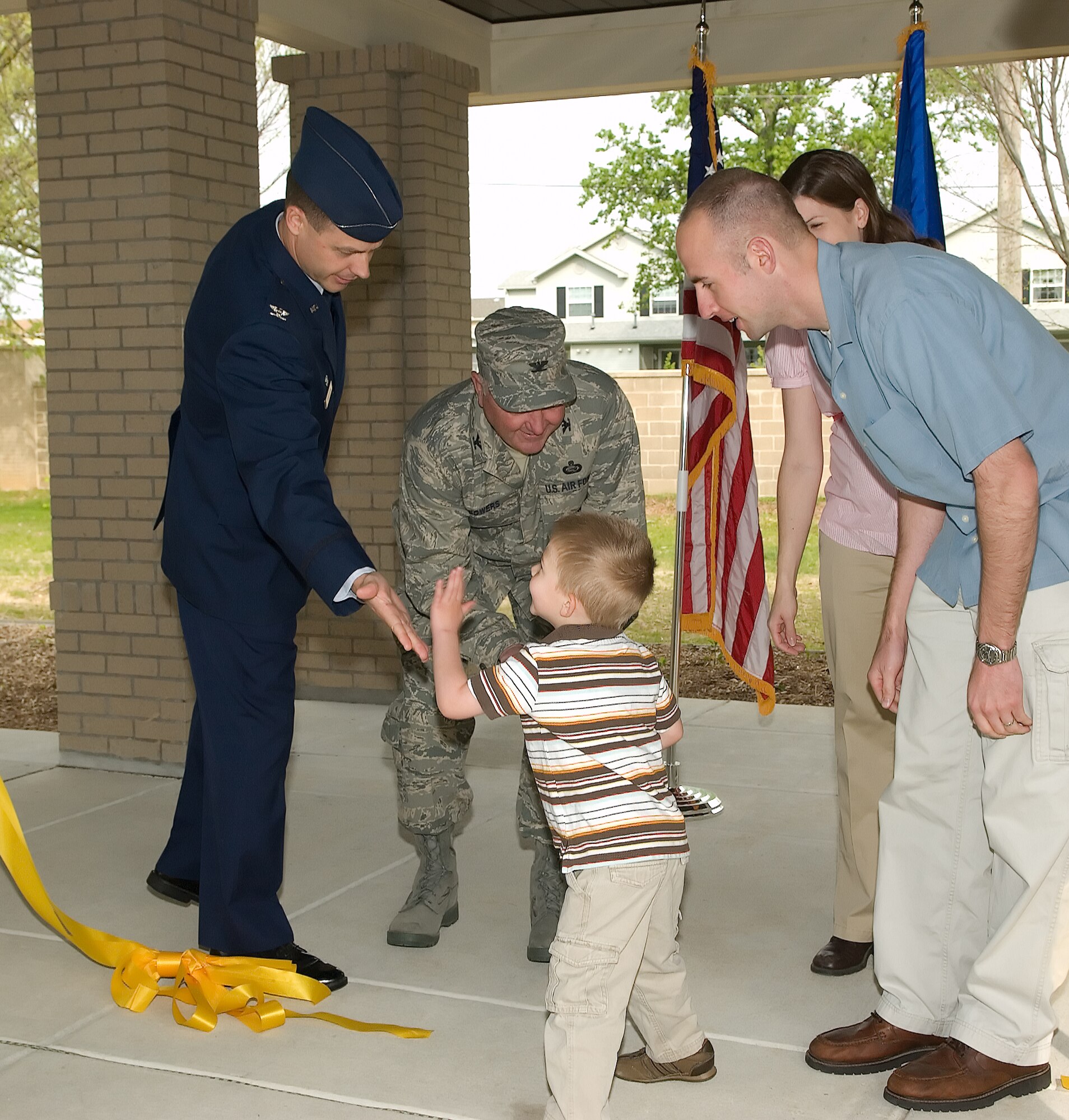 Ryan Kovarovic, 3, gives Col. Steven Harrison, 436th Airlift Wing commander, a high five while shaking hands with Col. Vic Sowers, 436th Mission Support Group commander, after he helped cut the ribbon on the new temporary lodging facility at Dover Air Force Base. Capt.  James and Angela Kovarovic, Ryan’s parents, also participated in the ceremony, as the first family to move into the new TLF.  Captain Kovarovic joins the 3rd Airlift Squadron.  (U.S. Air Force photo/Jason Minto)