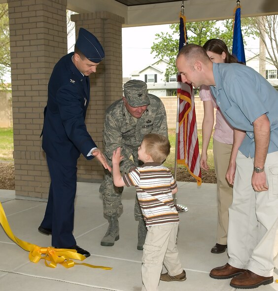 Ryan Kovarovic, 3, gives Col. Steven Harrison, 436th Airlift Wing commander, a high five while shaking hands with Col. Vic Sowers, 436th Mission Support Group commander, after he helped cut the ribbon on the new temporary lodging facility at Dover Air Force Base. Capt.  James and Angela Kovarovic, Ryan’s parents, also participated in the ceremony, as the first family to move into the new TLF.  Captain Kovarovic joins the 3rd Airlift Squadron.  (U.S. Air Force photo/Jason Minto)