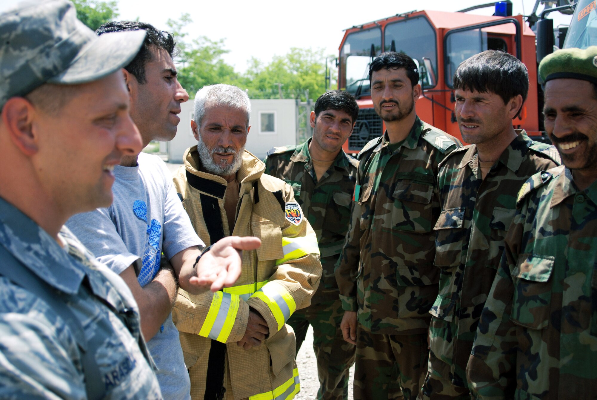 Master Sgt. Michael Marascia of the Combined Air Power Transition Force, congratulates his students from the Afghan National Army Air Corps after a successful firefighting exercise May 12 at Kabul, Afghanistan. The four-month course has been conducted under the sole mentorship of Sergeant Marascia, who is deployed from Langley Air Force Base, Va. (U.S. Air Force photo/Petty Officer 1st Class Douglas Mappin) 