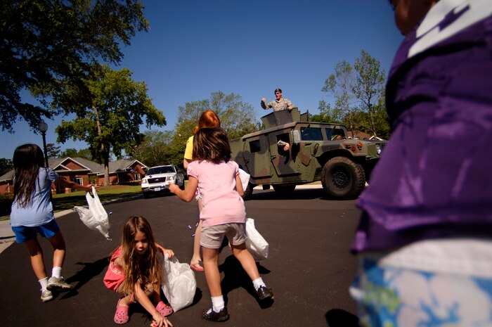 Lt. Col. Seth McKee throws candy to children during the Kids Candy Parade through base housing May 17. Colonel McKee is the 437th Security Forces Squadron commander. (U.S. Air Force photo/Senior Airman Nicholas Pilch)