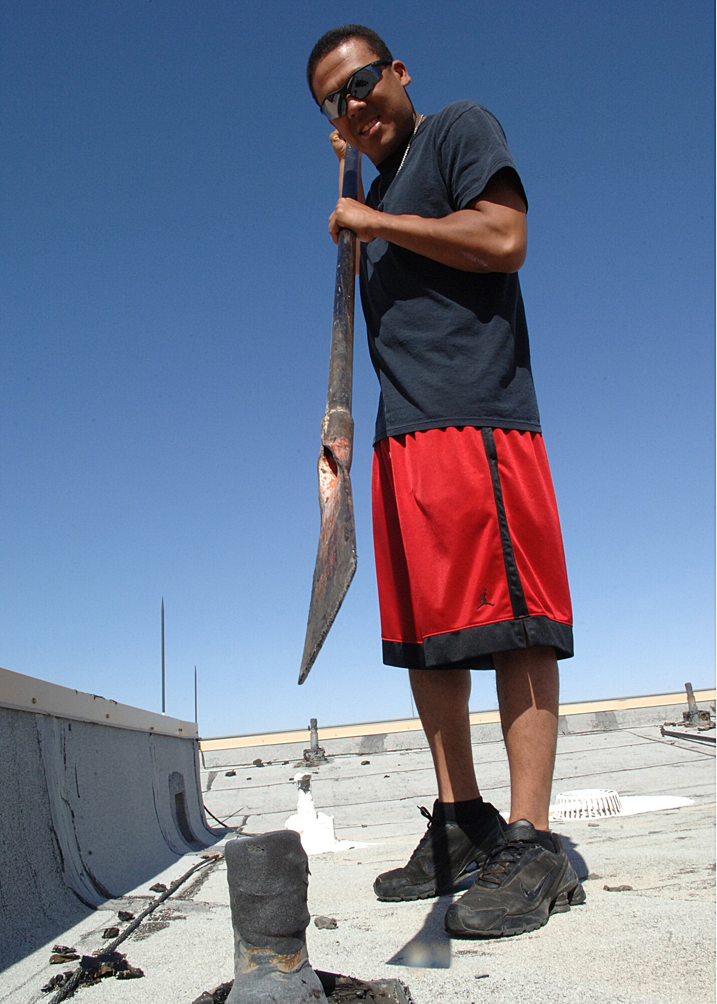 Airman First Class Luis Lopez of the 49th Aircraft Maintenance Squadron chips tar off of the roof of hangar 877 on May 13.  (U.S. Air Force photo/Airman 1st Class John D. Strong II)    
