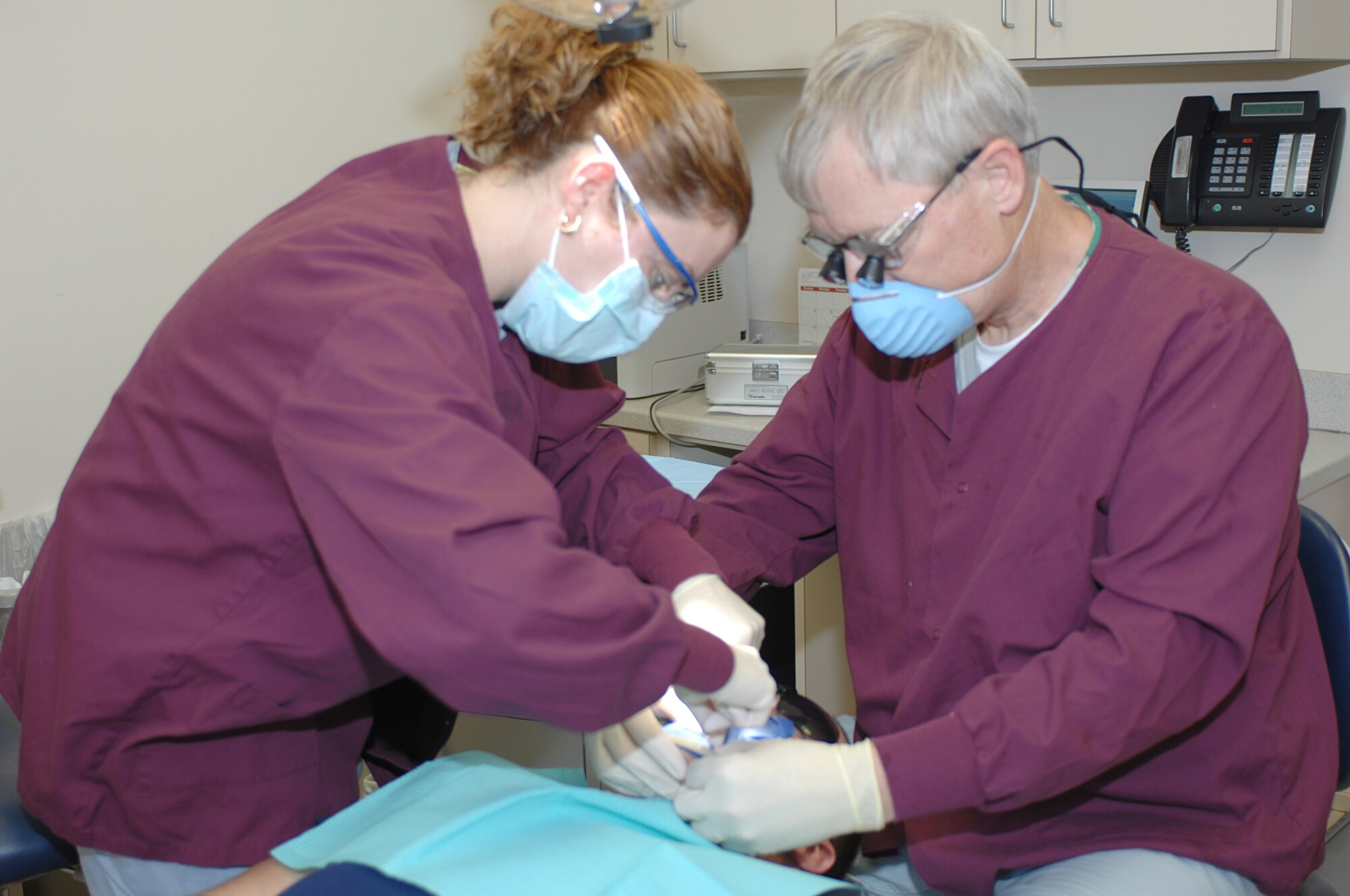 LANGLEY AIR FORCE BASE, Va. -- Mrs. Shelia Medina, an American Red Cross dental assistant program volunteer, assists Dr. James Waring, a dental surgeon from the 1st Dental Squadron, with a root canal here May 19. (U.S. Air Force photo/ Tech. Sgt. April Wickes)
