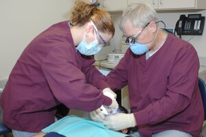 LANGLEY AIR FORCE BASE, Va. -- Mrs. Shelia Medina, an American Red Cross dental assistant program volunteer, assists Dr. James Waring, a dental surgeon from the 1st Dental Squadron, with a root canal here May 19. (U.S. Air Force photo/ Tech. Sgt. April Wickes)