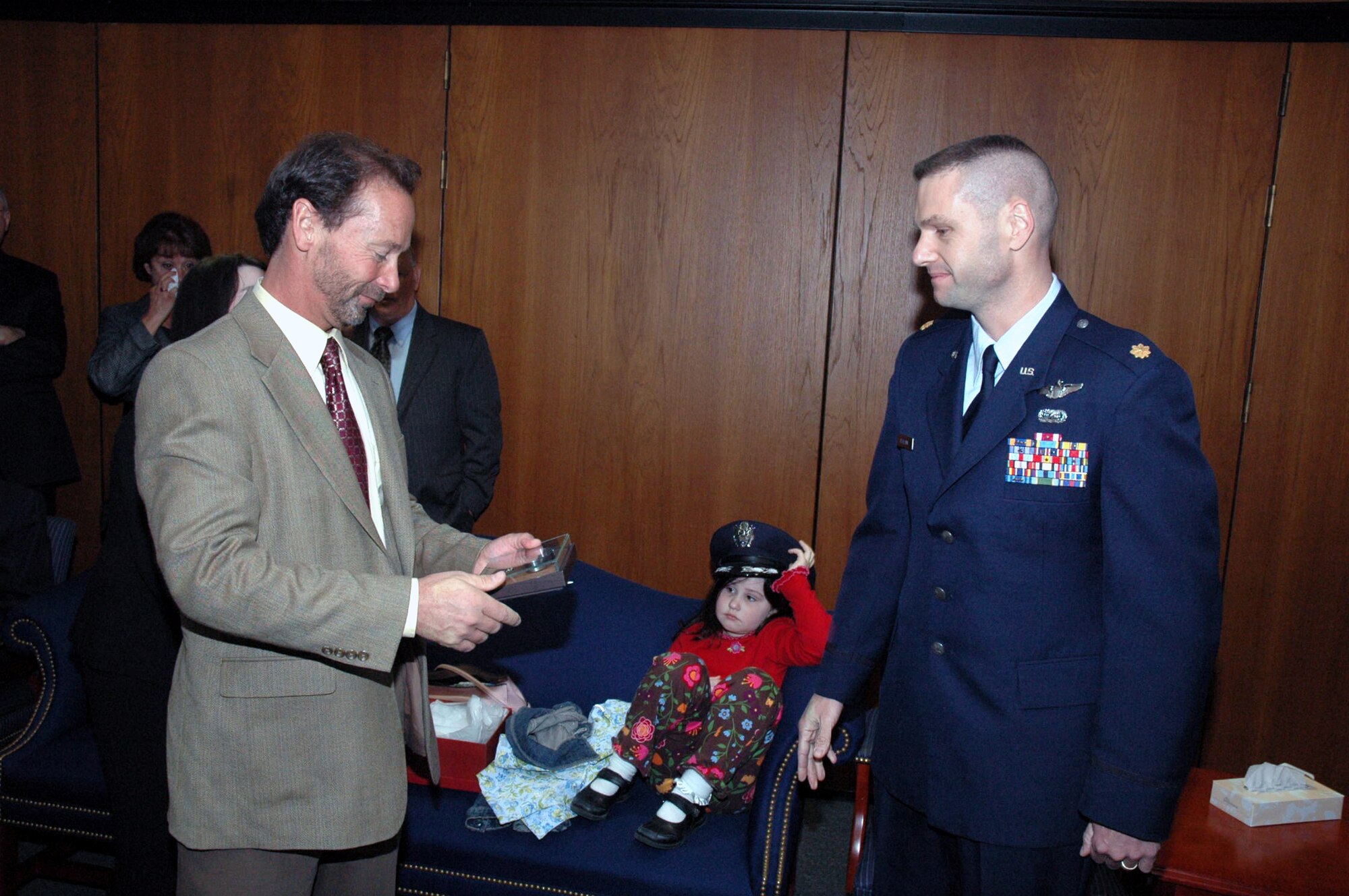 Maj. Phil Heseltine, U.S. Air Force Expeditionary Center executive officer to the commander, Fort Dix, N.J., presents a POW/MIA bracelet he wore for 18 years to the Chuck Woods, son of Maj. Robert F. Woods, whose name is on the bracelet, during the funeral for Major Woods at Arlington National Cemetery April 9, 2008.  Mr. Woods then presented the bracelet to his own son. (U.S. Air Force Photo/Tech. Sgt. Scott T. Sturkol)