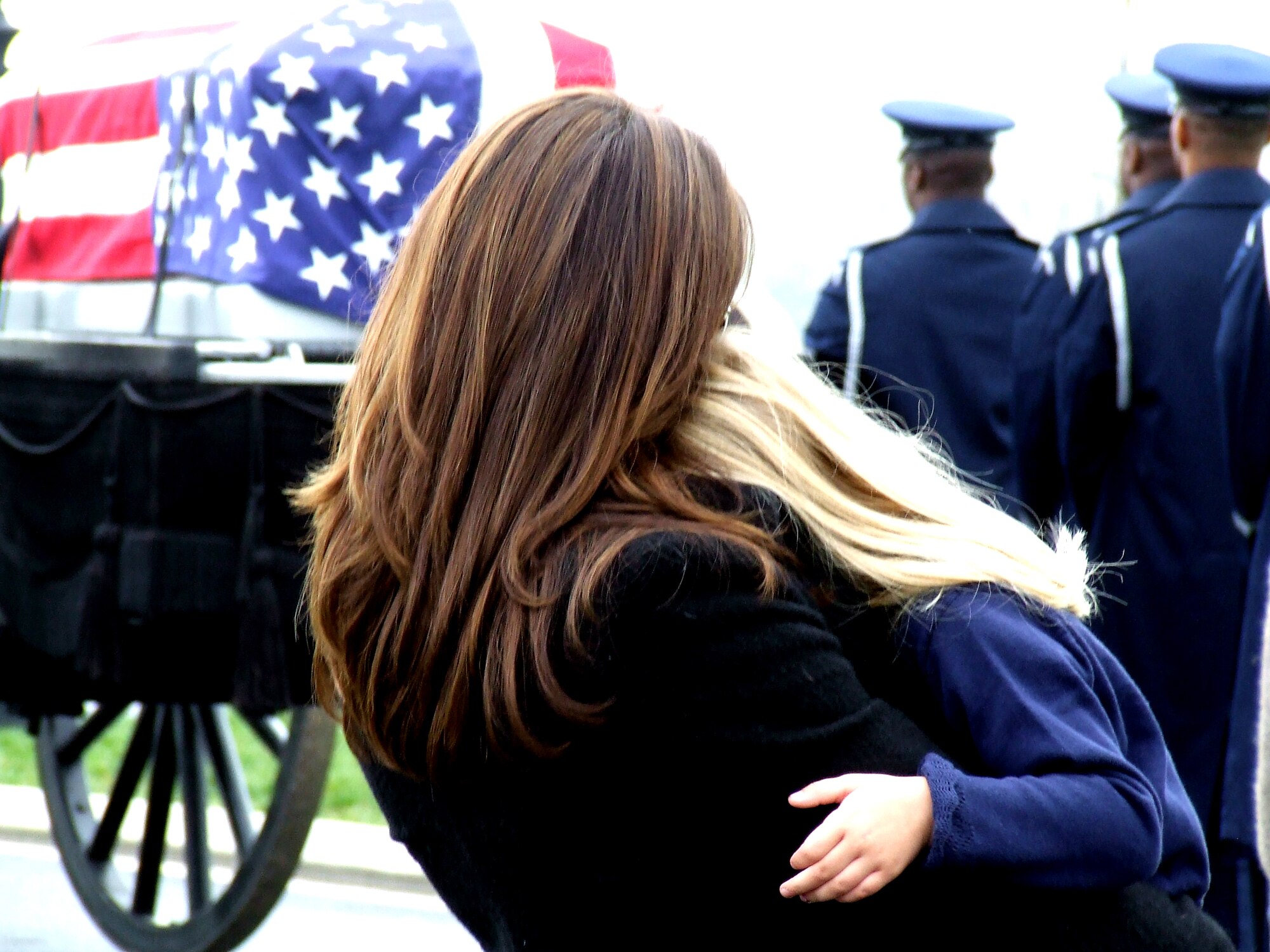 Family members of former missing in action Airman, Maj. Robert F. Woods, watch as the cason carrying him is prepared to move to a grave site April 9, 2008, at Arlington National Cemetery, Va.  On Nov. 30, 2007, the Air Force announced that Major Woods, along with co-pilot Capt. Johnnie C. Cornelius, were identified and their remains returned to the United States from Vietnam.  On June 26, 1968, Major Woods and Captain Cornelius were flying a visual reconaissance mission over Quang Binh Province, Vietnam, when their O-2A Skymaster aircraft crashed in a remote mountainous area.  Major Woods was buried with full military honors nearly 40 years after he disappeared in the crash.  (U.S. Air Force Photo/Tech. Sgt. Scott T. Sturkol)