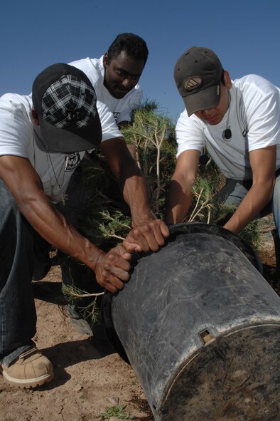Airman 1st Class Michael Bowens, Airman 1st Class Phillip Dowlat and Airman 1st Class Robert Barboza, all from the 49th Aircraft Maintenance Squadron, attempts to remove a tree from it's pot May 6 at Tierra De Suenos Park in Alamogordo, N.M. The Arimen, along with other members of the 49th Maintenance Group, has volunteered to do work in the city as part of the Personnel Improvement Program, a project designed to keep Holloman Air Force Base personnel constructive while waiting the arrival of the F-22A Raptor. (U.S. Air Force photo/Airman 1st Class Jamal D. Sutter)
