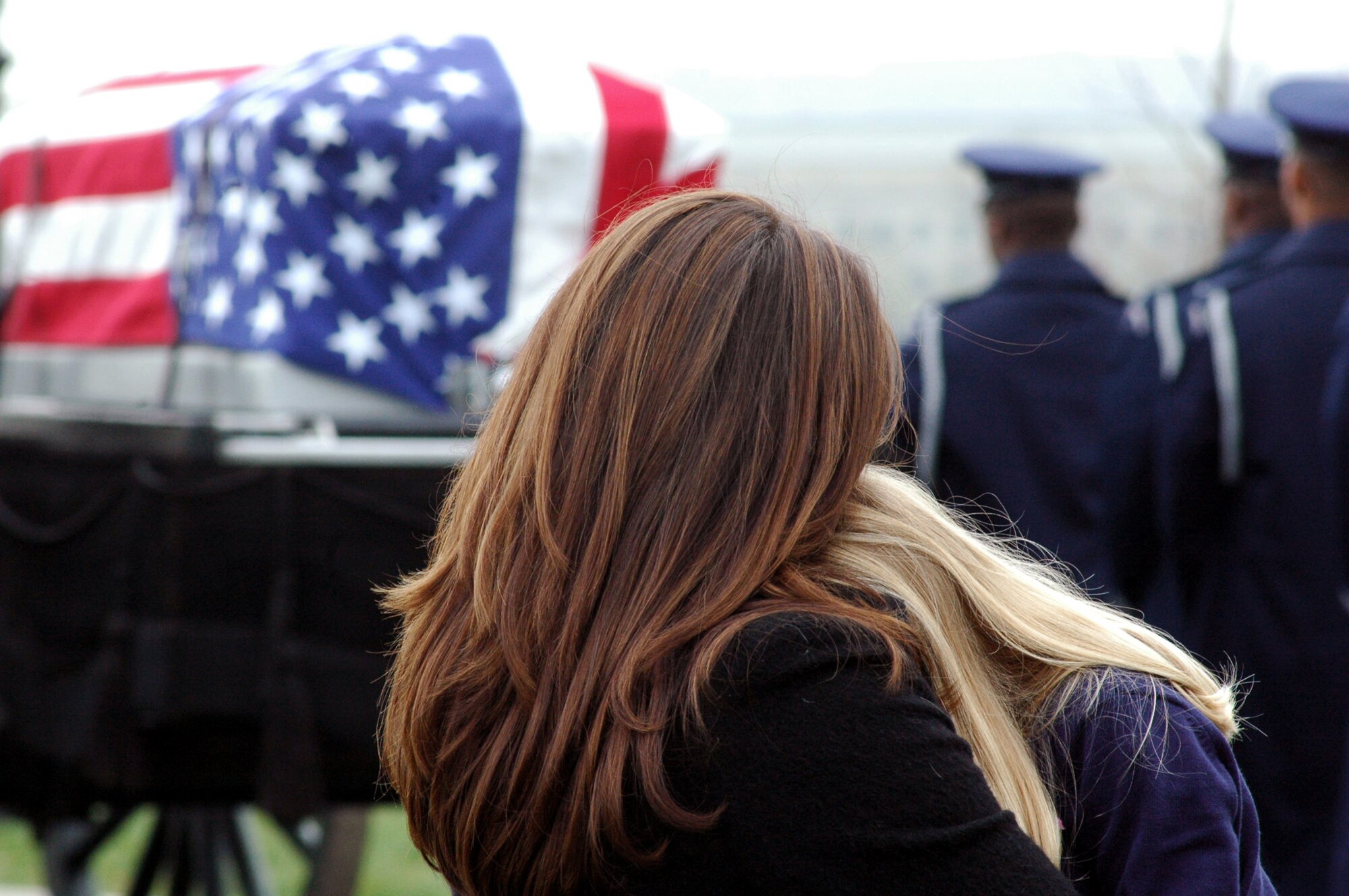 Family members of former missing in action Air Force Maj. Robert F. Woods watch as the cason carrying him is prepared to move to Major Wodds' gravesite April 9, 2008, at Arlington National Cemetery, Va.  On Nov. 30, 2007, the Air Force announced that Major Woods, along with co-pilot Capt. Johnnie C. Cornelius, were identified and their remains returned to the United States from Vietnam.  On June 26, 1968, Major Woods and Captain Cornelius were flying a visual reconaissance mission over Quang Binh Province, Vietnam, when their O-2A Skymaster aircraft crashed in a remote mountainous area.  Major Woods was buried nearly 40 years after he disappeared in the crash.  (U.S. Air Force Photo/Tech. Sgt. Scott T. Sturkol)