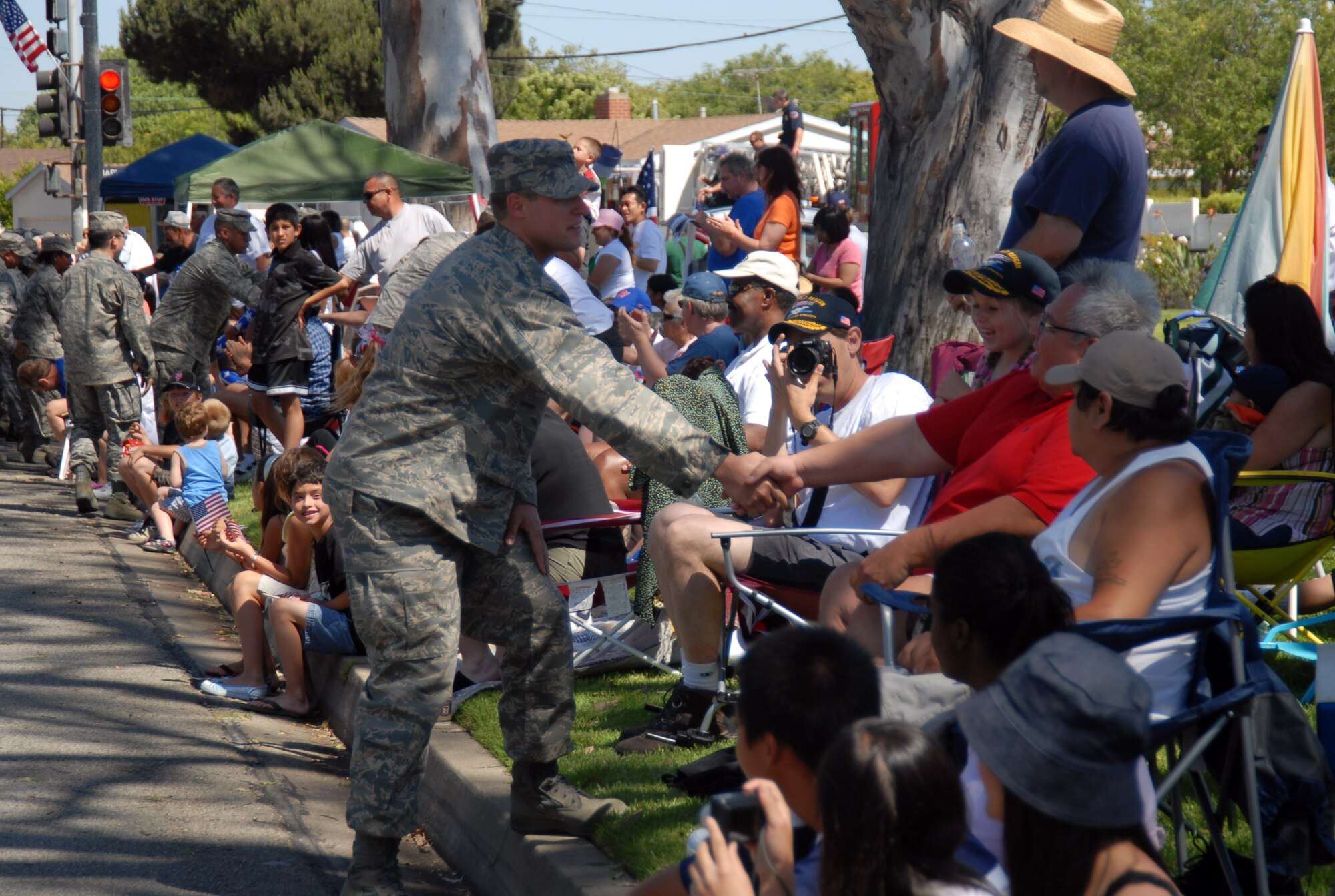 An Airman shakes the hand of a man during the 49th Annual Torrance Armed Forces Day celebration in Torrance, Calif., on May 17. The Torrance parade is the nation's longest running military parade sponsored by any city. (Air Force photo by Senior Airman Julius Delos Reyes)