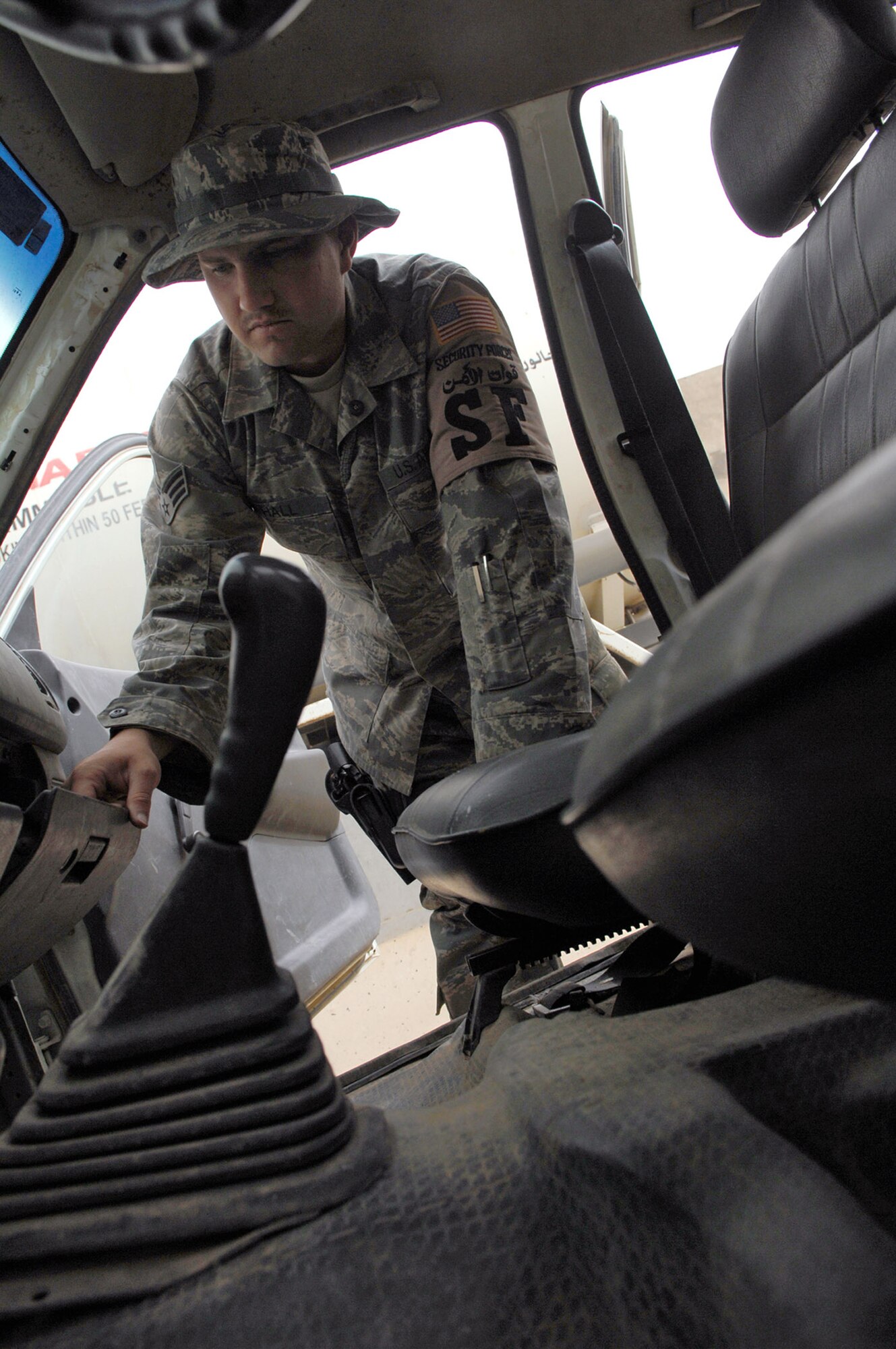 Senior Airman Branden Hall looks in the glove compartment of a vehicle May 17 at Balad Air Base, Iraq. Preventing unauthorized items from entering the base via vehicles or personnel ensures the safety of those assigned to the base. Airman Hall is a 332nd Expeditionary Security Forces Squadron force protection inspector deployed from Luke Air Force Base, Ariz. (U.S. Air Force photo/Senior Airman Julianne Showalter) 
