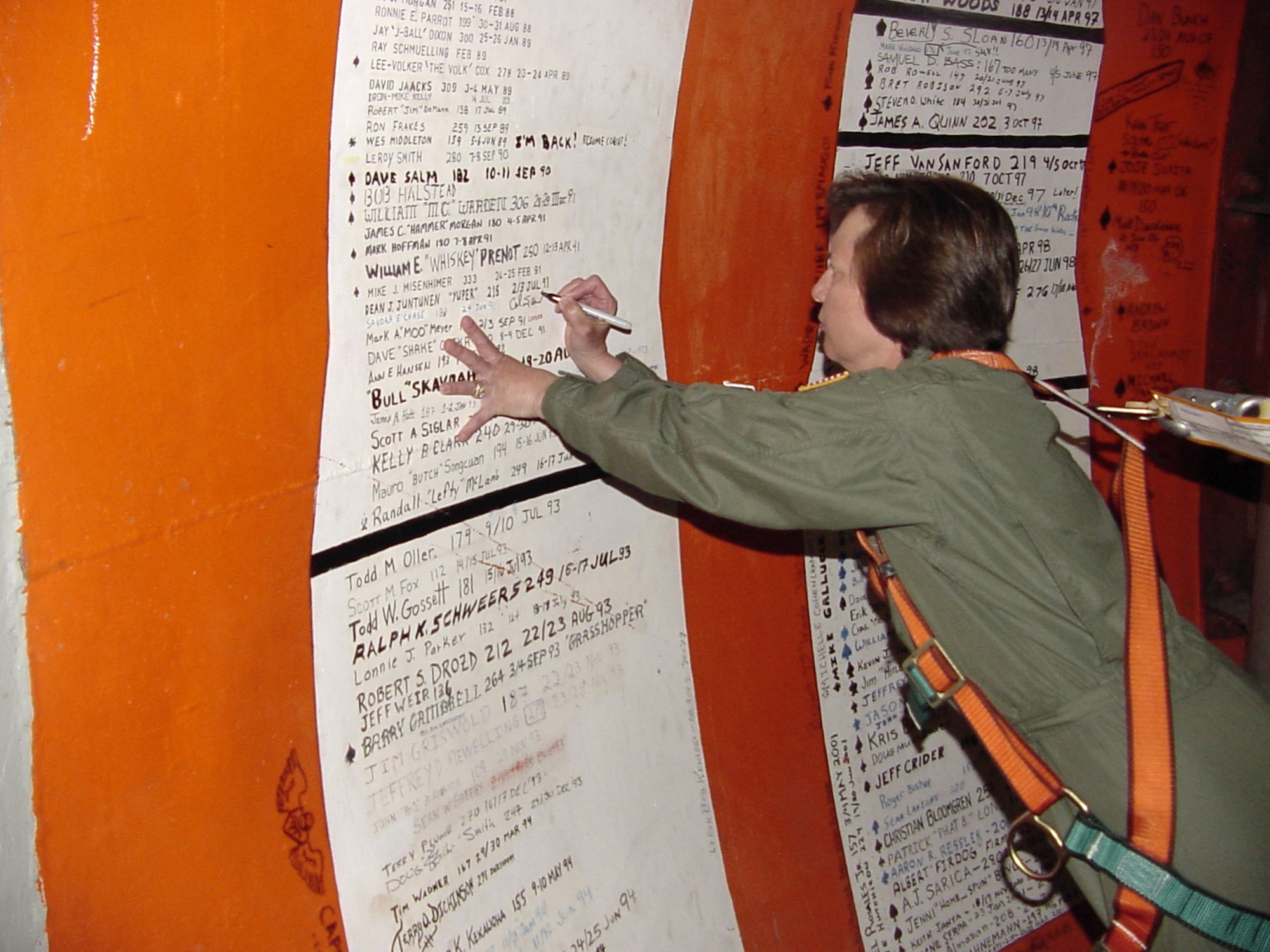 Col. Sandy Finan, 341st Space Wing commander, signs her name on the wall of the 10th Missile Squadron Alpha-01 Missile Alert Facility for the second time in her career before leaving Malmstrom for her next assignment. It is a tradition among missileers at Alpha- 01 to sign the wall after completing their final alert. Colonel Finan's last alert as a missile combat crew member was June 24, 1991.   (U.S. Air Force photo/ Airman 1st Class Dillon White)