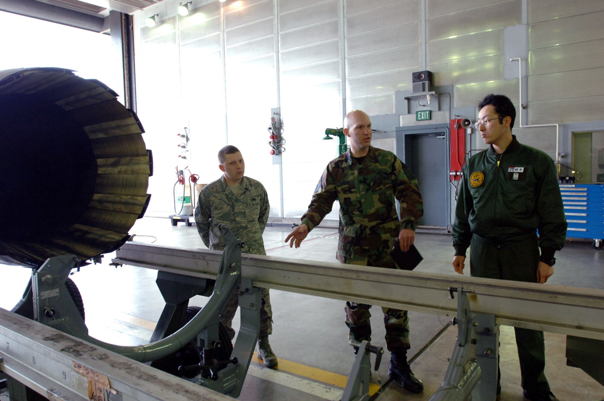 Staff Sgt. Joseph Bilger (left) and Tech. Sgt. Marcus Sydow (center) introduce Japanese Air Self Defense Force Staff Sgt. Masanobu Suzuki to some of their equipment May 15 at Misawa Air Base, Japan. The purpose of this bilateral exchange is to build friendships and learn the differences between both forces within the same job. Sergeant Bilger is a 35th propulsion flight jet engine mechanic, and Sergeant Sydow is the 35th propulsion shop nonpowered age NCO in charge. (U.S. Air Force photo/Senior Airman Robert Barnett) 
