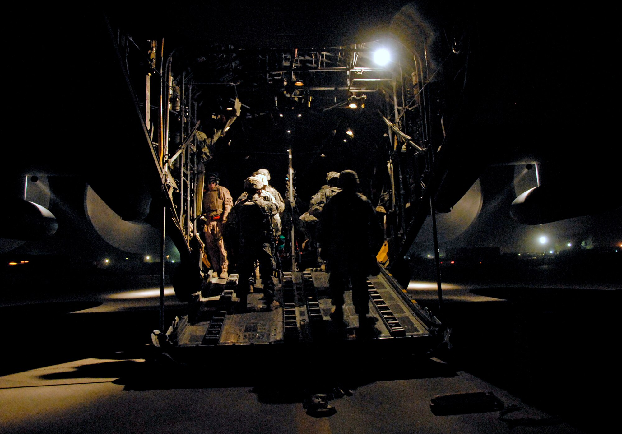 Senior Airman Joel Pfaff stands next to the rear left troop cargo door ensuring all passengers make it onboard safely during a passenger/cargo mission May 13 to an air base in Iraq. Airman Pfaff is a C-130 Hercules loadmaster with the 737th Expeditionary Airlift Squadron deployed from Dyess Air Force Base, Texas, and the Soldiers returning home from a 14-month deployment are from the A Battery, 1-10 Field Artillery, 3rd Brigade Combat Team, 31st Division out of Fort Benning, Ga. (U.S. Air Force photo/Tech. Sgt. Michael O'Connor) 
