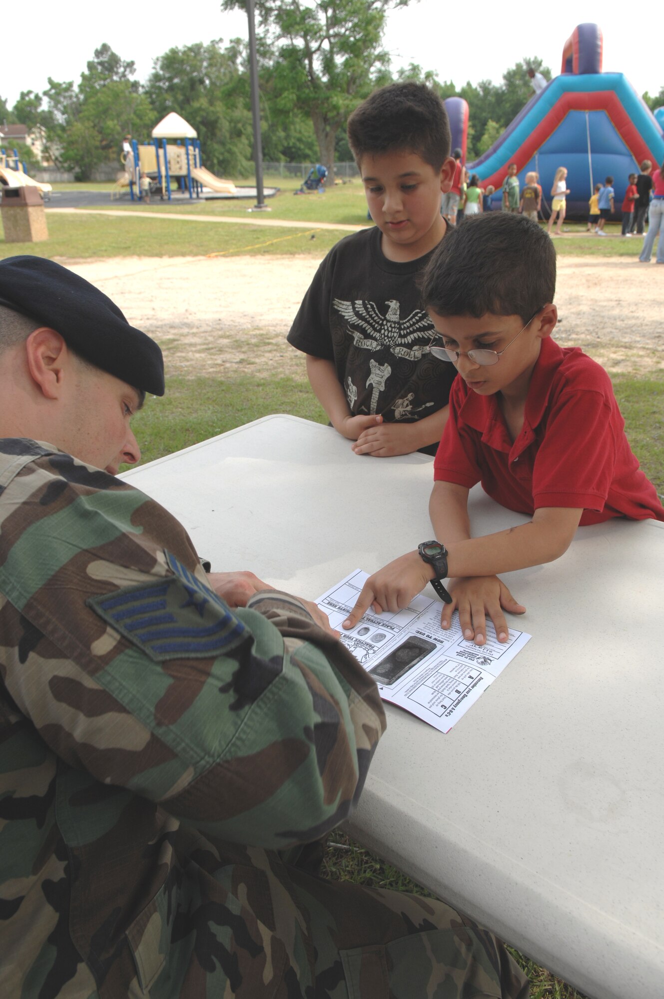 SHAW AIR FORCE BASE, S.C. -- Tech Sgt. Todd Coleman, 20th Security Forces Squadron NCO in charge of community policing, assists eight-year-old Nathan Dudani, son of Maj. Leah and Mahender Dudani, with fingerprinting while eight-year-old Timothy Jones, son of Staff Sgt. Roy and Chantil Jones, waits his turn during a block party in observance of Police Week May 16. May 15 is National Peace Officers Memorial Day and the week containing May 15 is National Police Week since President John F. Kennedy signed Public Law 87-726 Oct. 1, 1962. (U.S. Air Force photo/Staff Sgt. Nathan Bevier)