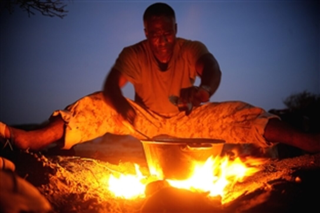 U.S. Navy Seabee Jean Joseph cooks goat meat for dinner during a 10-day French tactical desert survival training course, May 9, 2008. Forty U.S. troops stationed at Camp Lemonier, Djibouti, volunteered for the course taught by French marines of the 5th Regiment Overseas Infantry. Joseph is assigned to the Combined Joint Task Force-Horn of Africa.