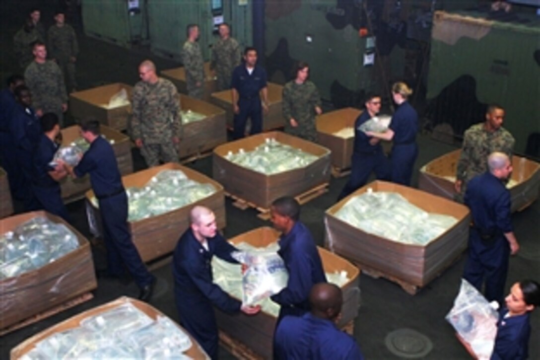 U.S. sailors and Marines aboard the USS Essex fill boxes with 16-liter water bladders to prepare for humanitarian assistance for Burmese victims of Cyclone Nargis, May 16, 2008.