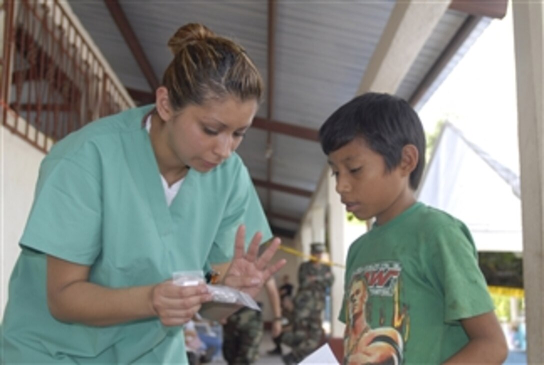 U.S. Navy Aviation Boatswain's Mate Airman Amy Saavedra from the USS Boxer (LHD 4) explains medicine dosage instructions to a Guatemalan child in Escuela Las Pampas, Guatemala, on May 15, 2008.  The Boxer is deployed to Latin America with various embarked units and nongovernmental organizations in support of Continuing Promise 2008.  Medical and civil engineering services will be provided in Guatemala, El Salvador and Peru.  