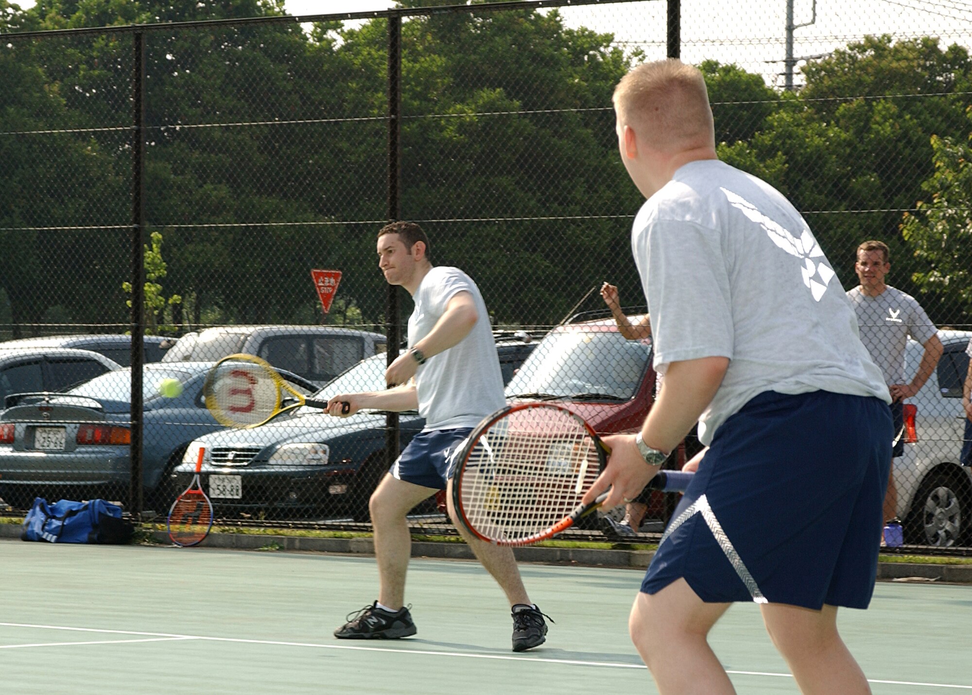 YOKOTA AIR BASE, Japan - 1st Lt. Matthew Taylor returns a serve while teammate Senior Airman James Huatsman watches during Yokota's 2008 Safety and Sports Day on May 22. Lt. Taylor and SrA Huatsman are both from the 36th Airlift Squadron. (U.S. Air Force photo by Airman 1st Class Jonathan Fowler)                               