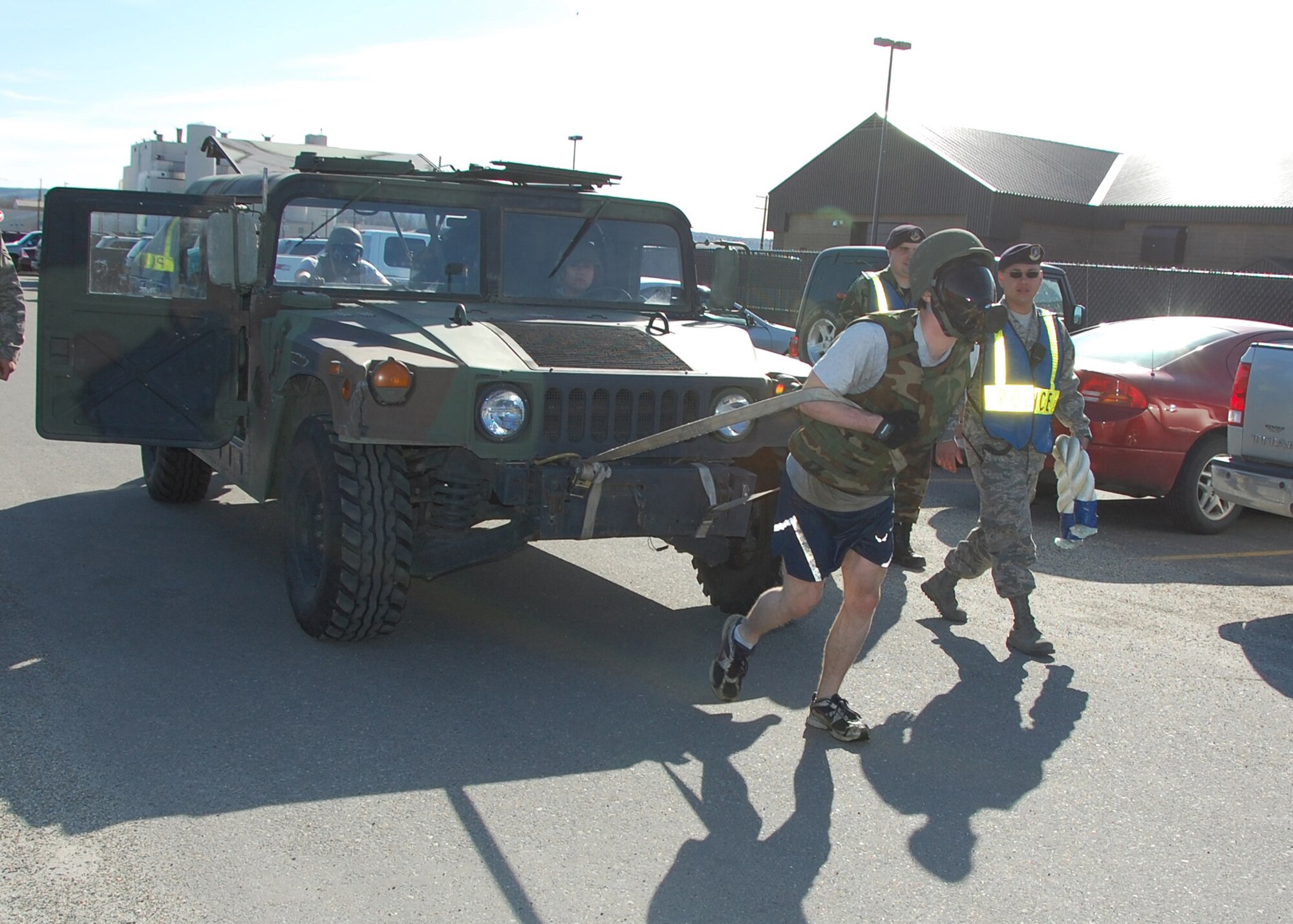 Senior Airman Robbie Southards of the 354th Civil Engineer Squadron ?Chem Pigs? pulls a Humvee 100 meters as his teammates push from behind May 14, 2008, at Eielson AFB, Alaska. The ?Chem Pigs? are participating in a Police Week Marathon sponsored by the 354th Security Forces Squadron. The marathon consisted of a variety of physical and mental obstacles, such as running 1.5 miles, a keep-in-memory game, various calisthenics and low crawling a total of 150 meters.  The Chem Pigs wore gas masks as part of their team uniform. They came in third place with a time of 43:06. (U.S. Air Force photo by Airman 1st Class Nora Anton)