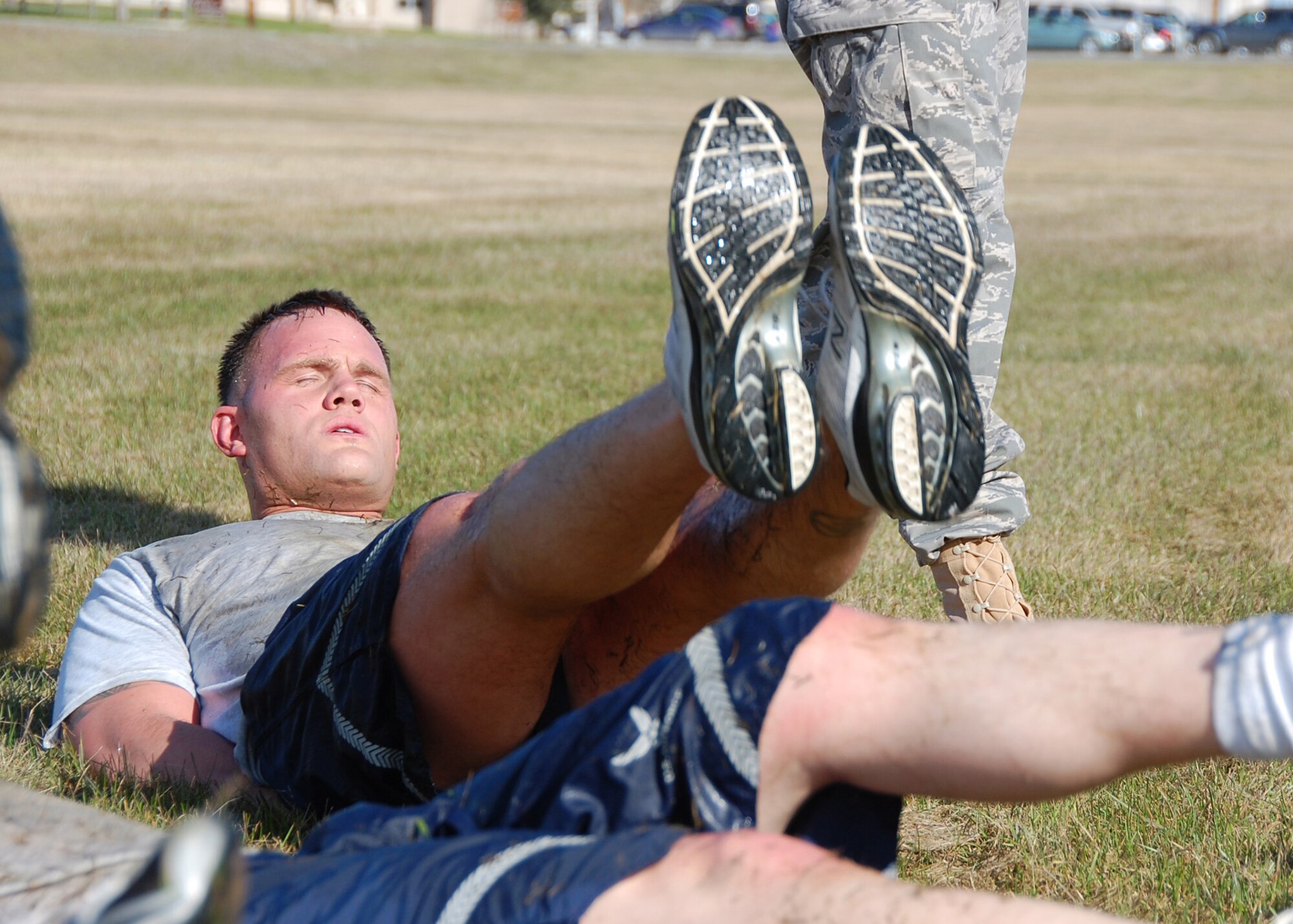 Staff Sgt. Lucas Dahlman, 354th Security Forces Squadron, leads his team in 50 four-count flutter kicks after low-crawling 50 meters during the Police Week Warrior Challenge May 14, 2008, at Eielson AFB, Alaska. The challenge consisted of a variety of physical and mental obstacles, such as running 1.5 miles, a keep-in-memory game, various calisthenics and low crawling a total of 150 meters. The 354th Security Forces Squadron ?Cops? came in second place to the 354th Maintenance Squadron ?Styers Strikers? with a time of 36:44. (U.S. Air Force photo by Airman 1st Class Nora Anton)