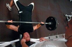 Gary West spots Brian Parker during a workout in the weight room of the base Fitness and Sports Center May 21. The Fitness and Sports Center is open 4:30 a.m. to midnight weekdays and 6:30 a.m. to 6 p.m. weekends. West is from the 15th Airlift Squadron and Parker is from the 437th Aircraft Maintenance Squadron. (U.S. Air Force photo/Senior Airman Nicholas Pilch)