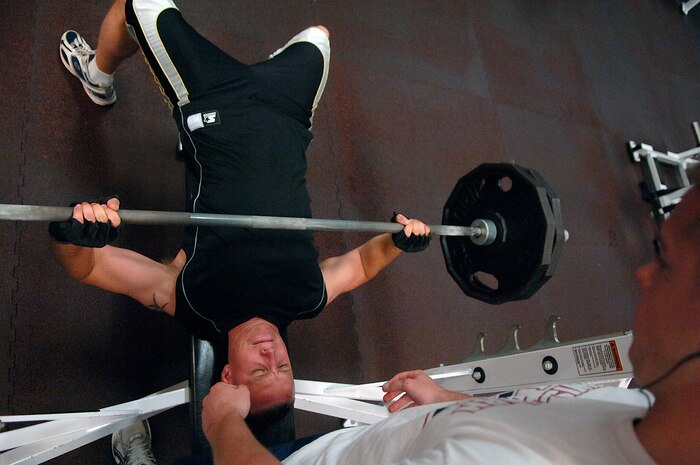 Gary West spots Brian Parker during a workout in the weight room of the base Fitness and Sports Center May 21. The Fitness and Sports Center is open 4:30 a.m. to midnight weekdays and 6:30 a.m. to 6 p.m. weekends. West is from the 15th Airlift Squadron and Parker is from the 437th Aircraft Maintenance Squadron. (U.S. Air Force photo/Senior Airman Nicholas Pilch)